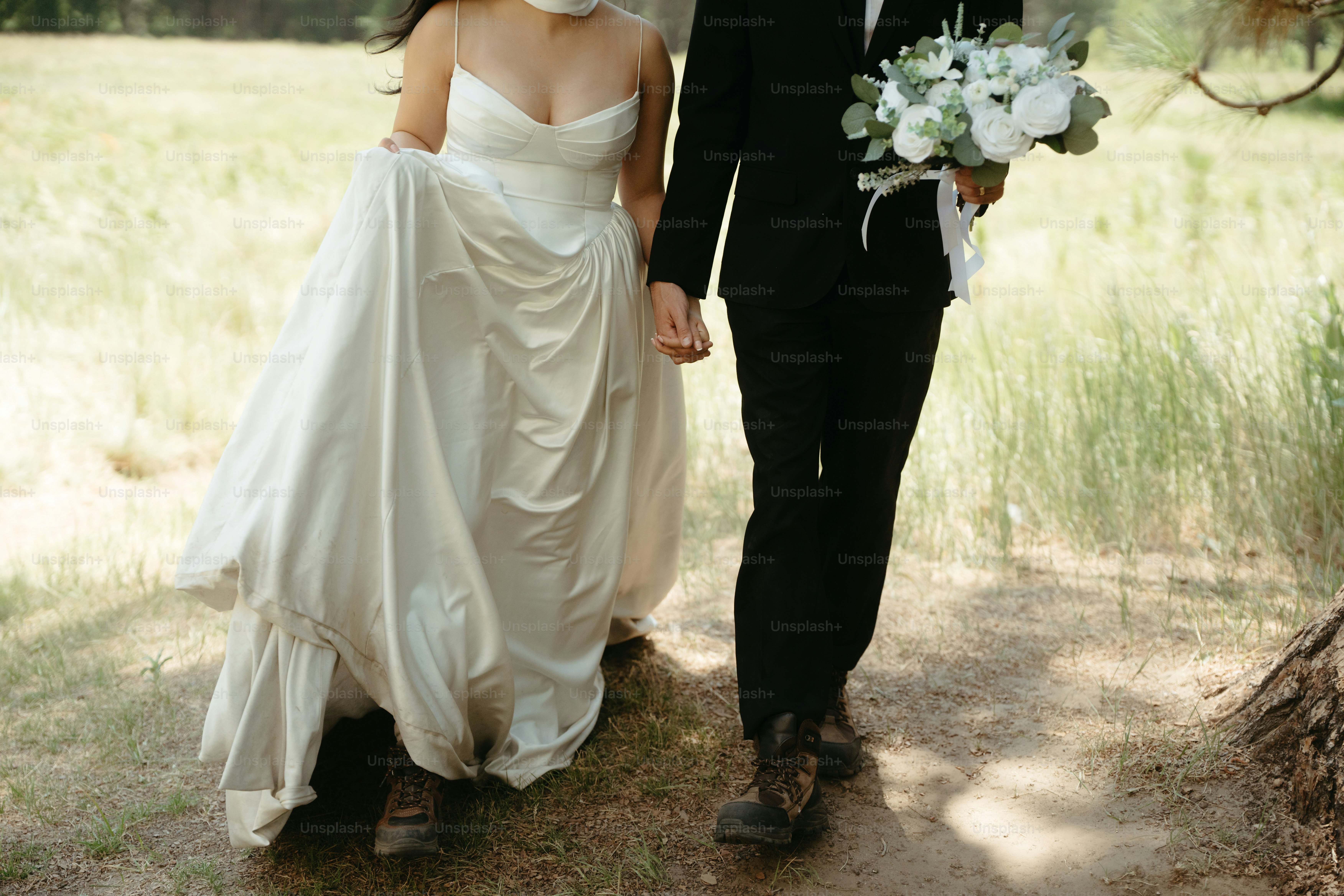 Bride and groom walking hand-in-hand with bouquet