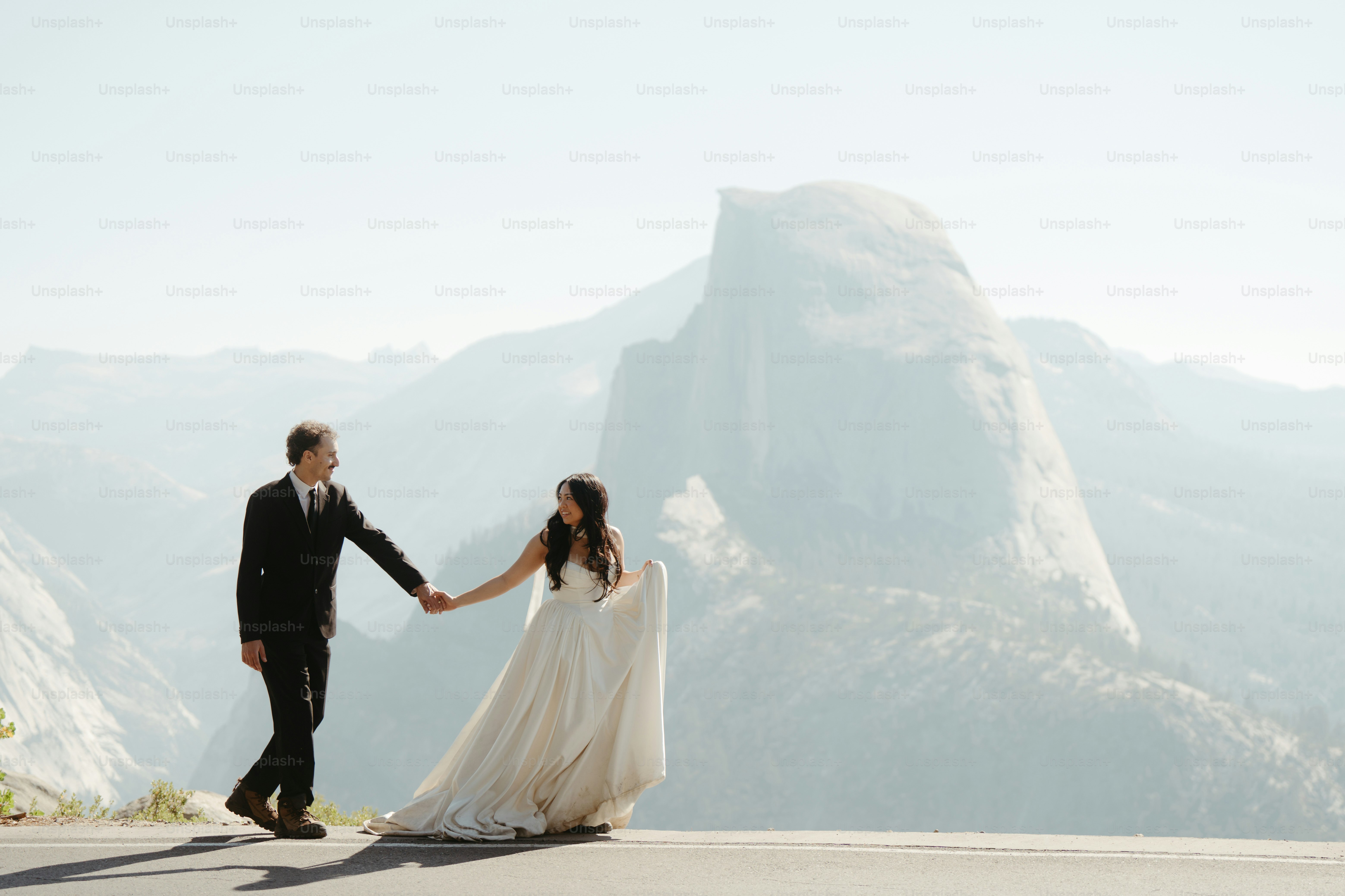 Couple holding hands with half dome in background
