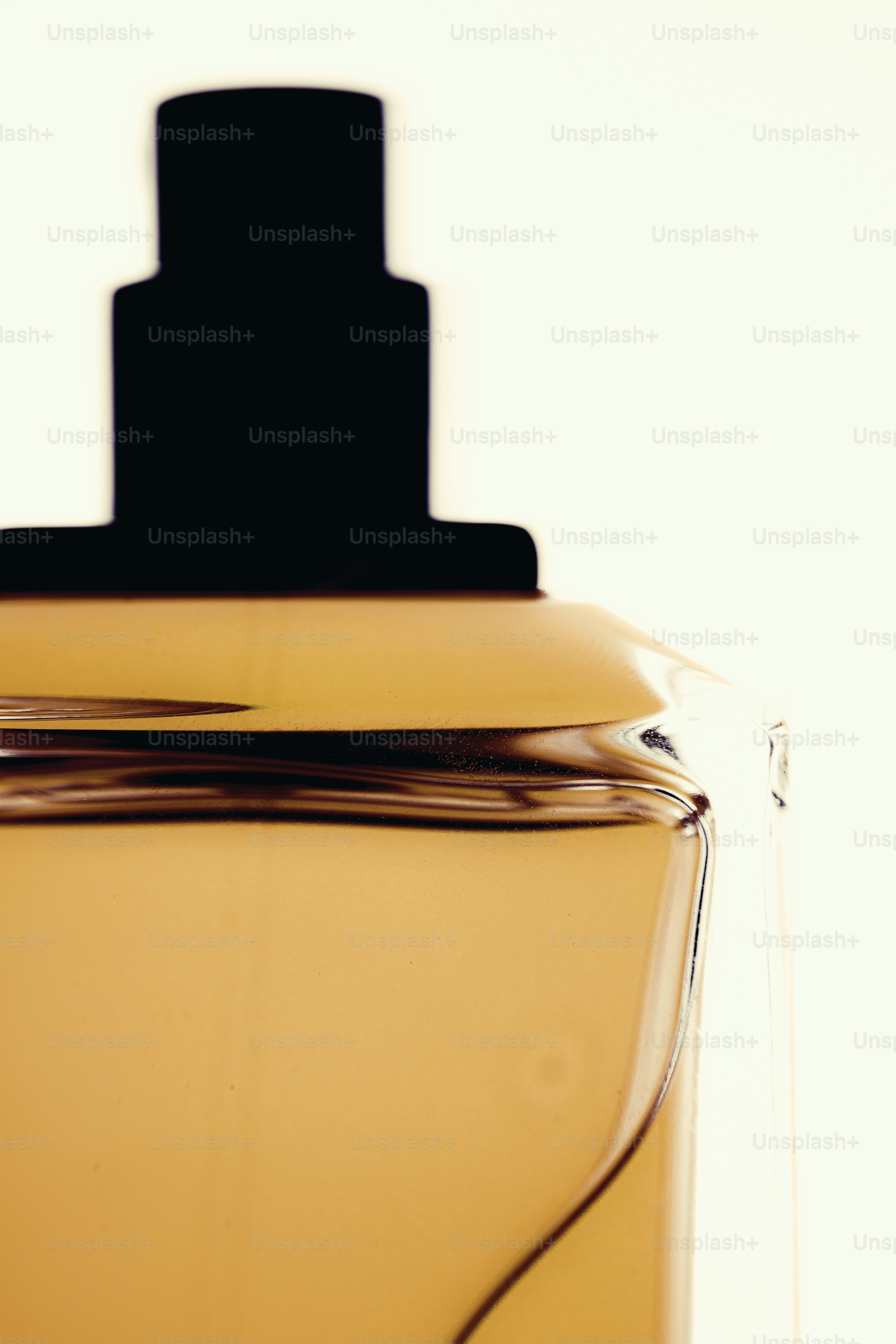 Un primo piano di una bottiglia di profumo con un tappo nero