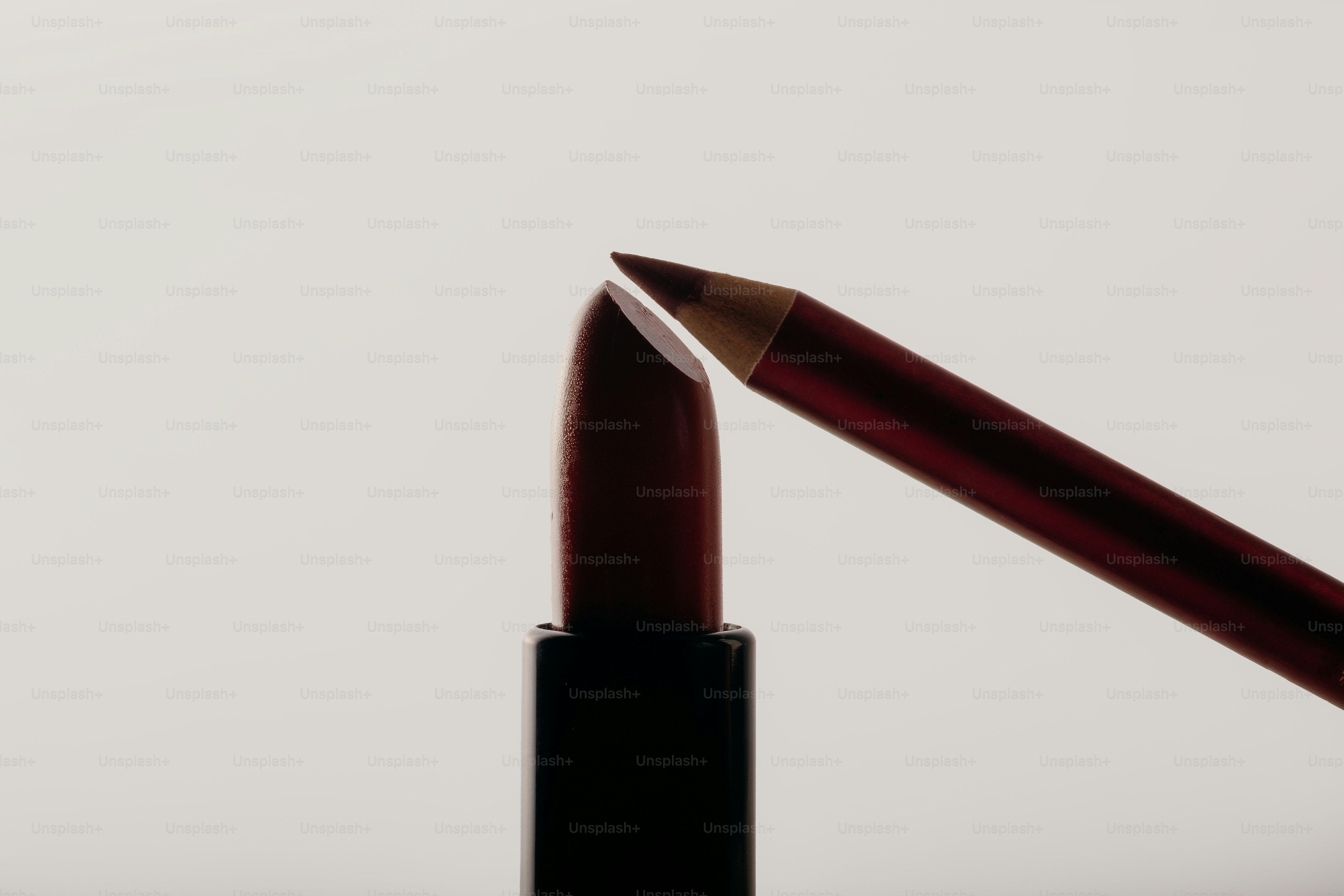 A dark red lipstick and lip liner pencil
