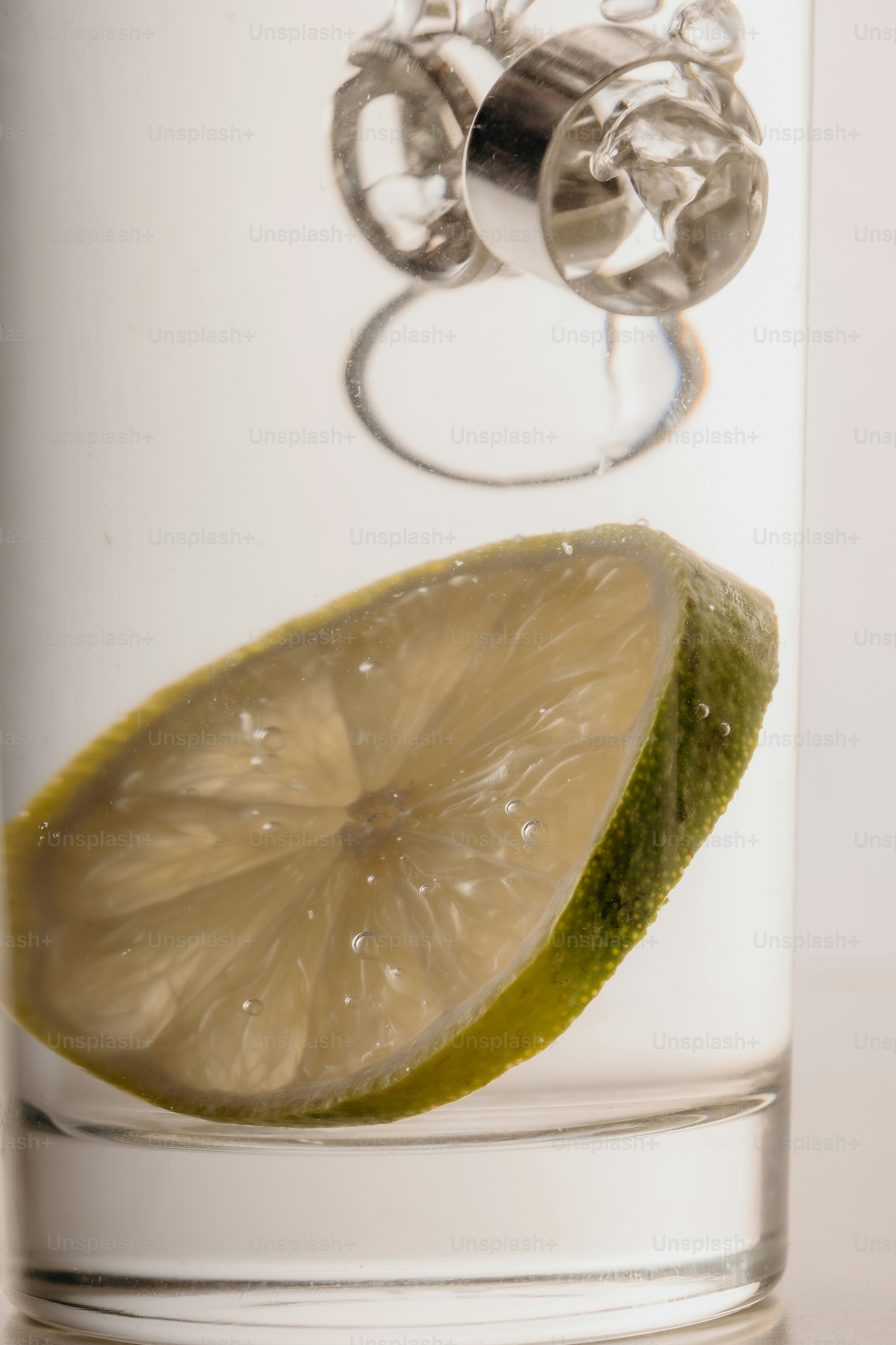 Rodaja de lima sumergida en líquido transparente con burbujas