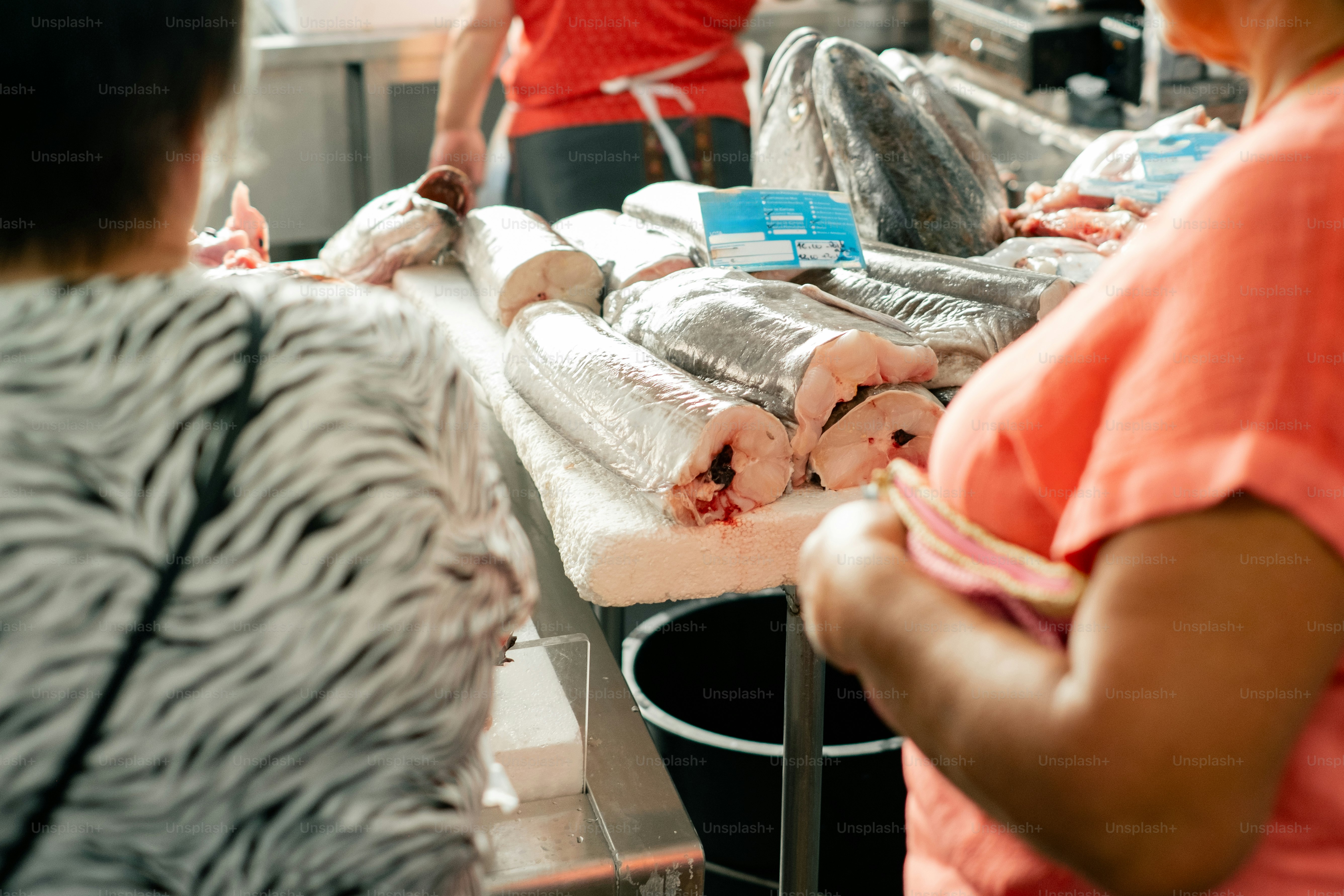 People shopping for fresh fish at market.