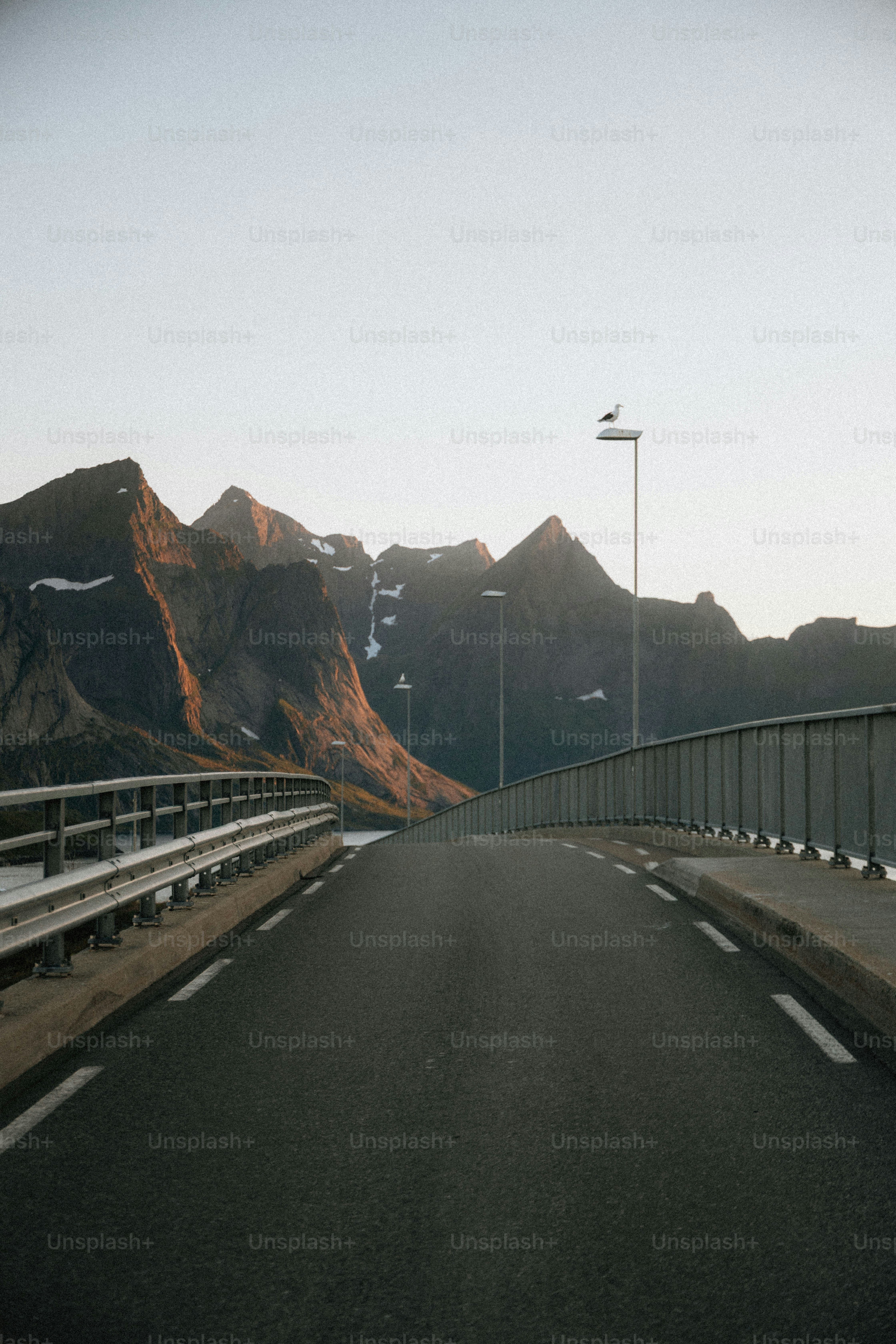 Pont menant à des montagnes majestueuses sous un ciel dégagé