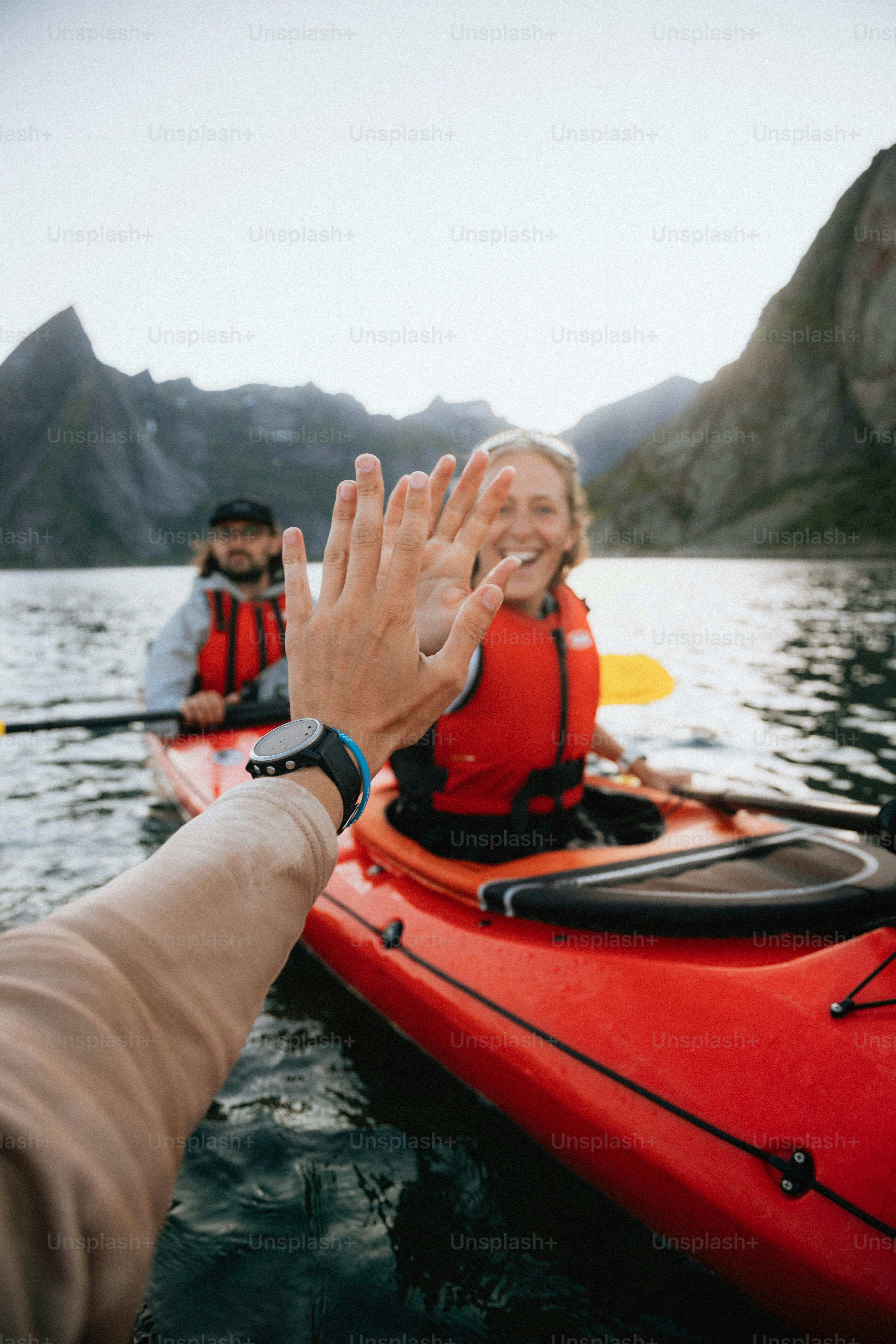 Deux personnes font du kayak et donnent un high five