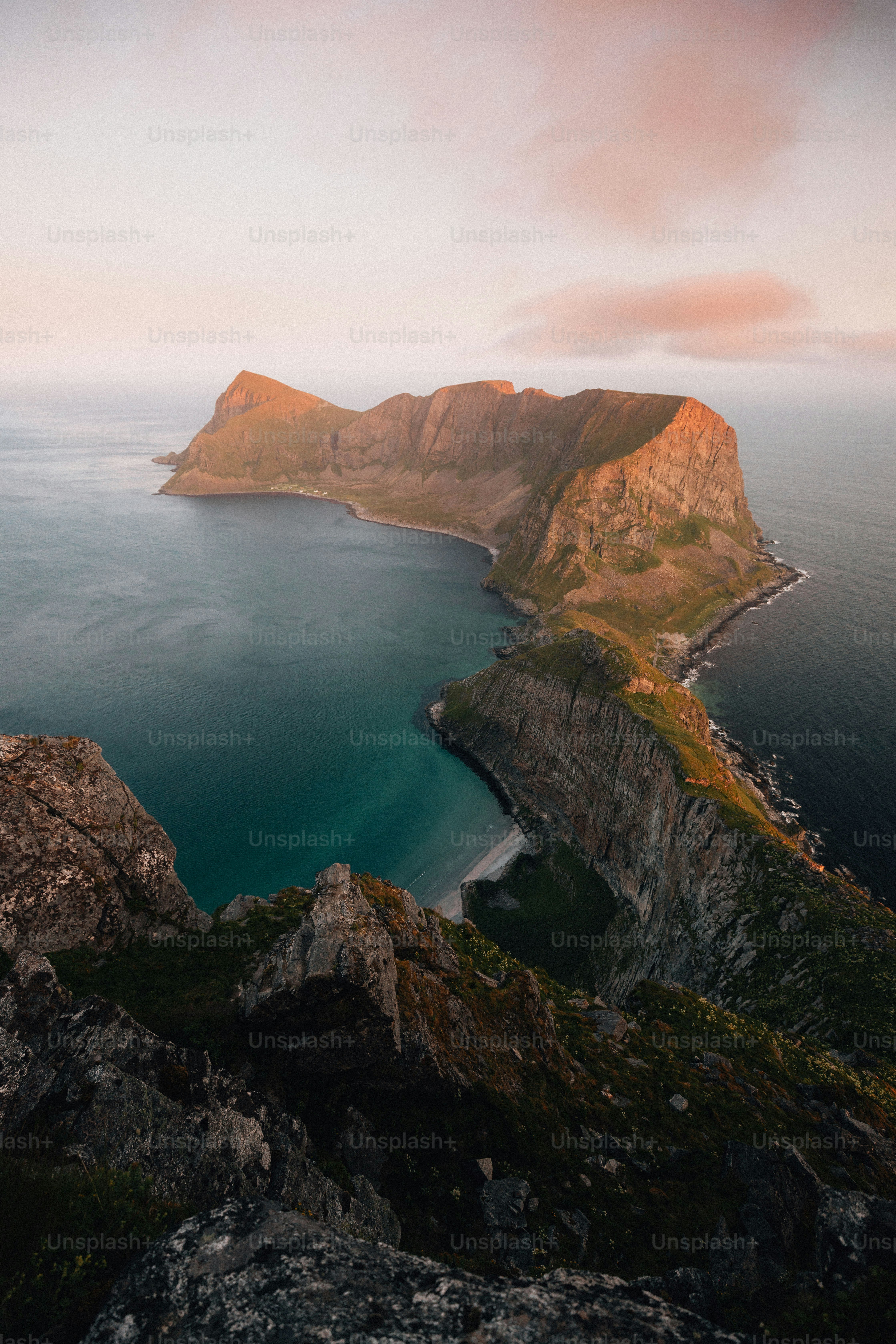 Paysage insulaire accidenté au lever du soleil avec des eaux océaniques calmes.