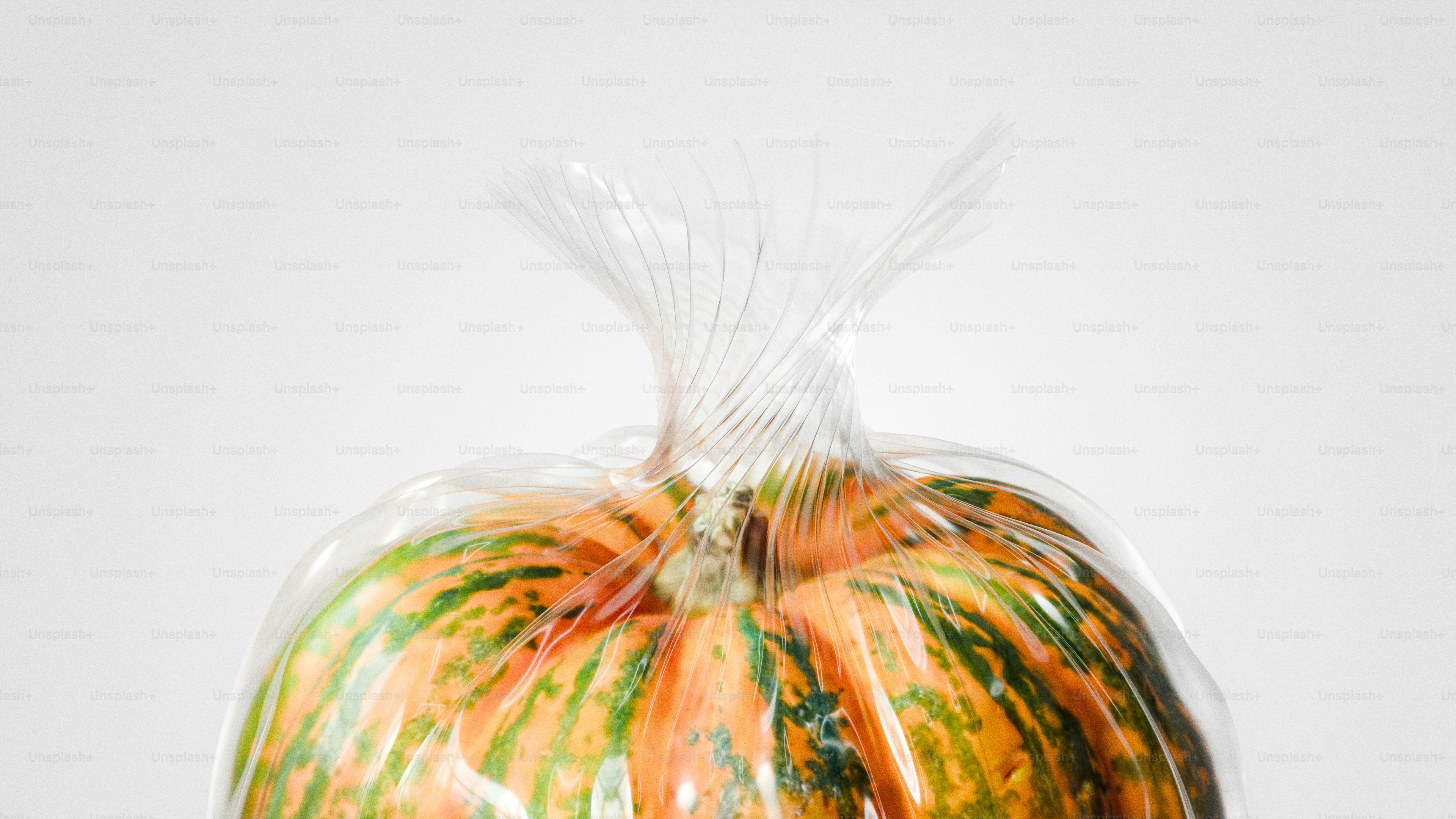 A striped pumpkin sealed in clear plastic packaging.