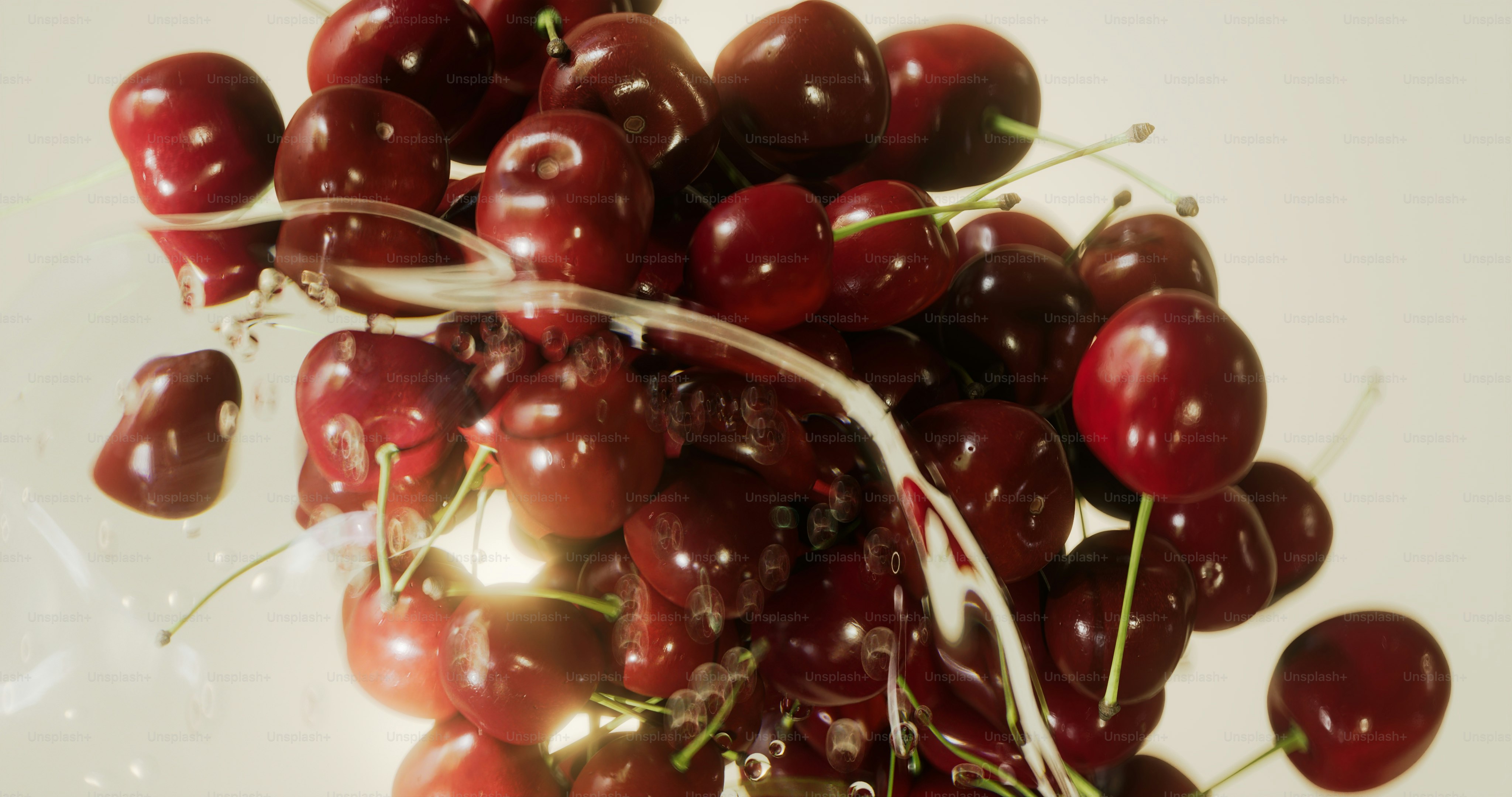 A pile of fresh, ripe cherries with water droplets.