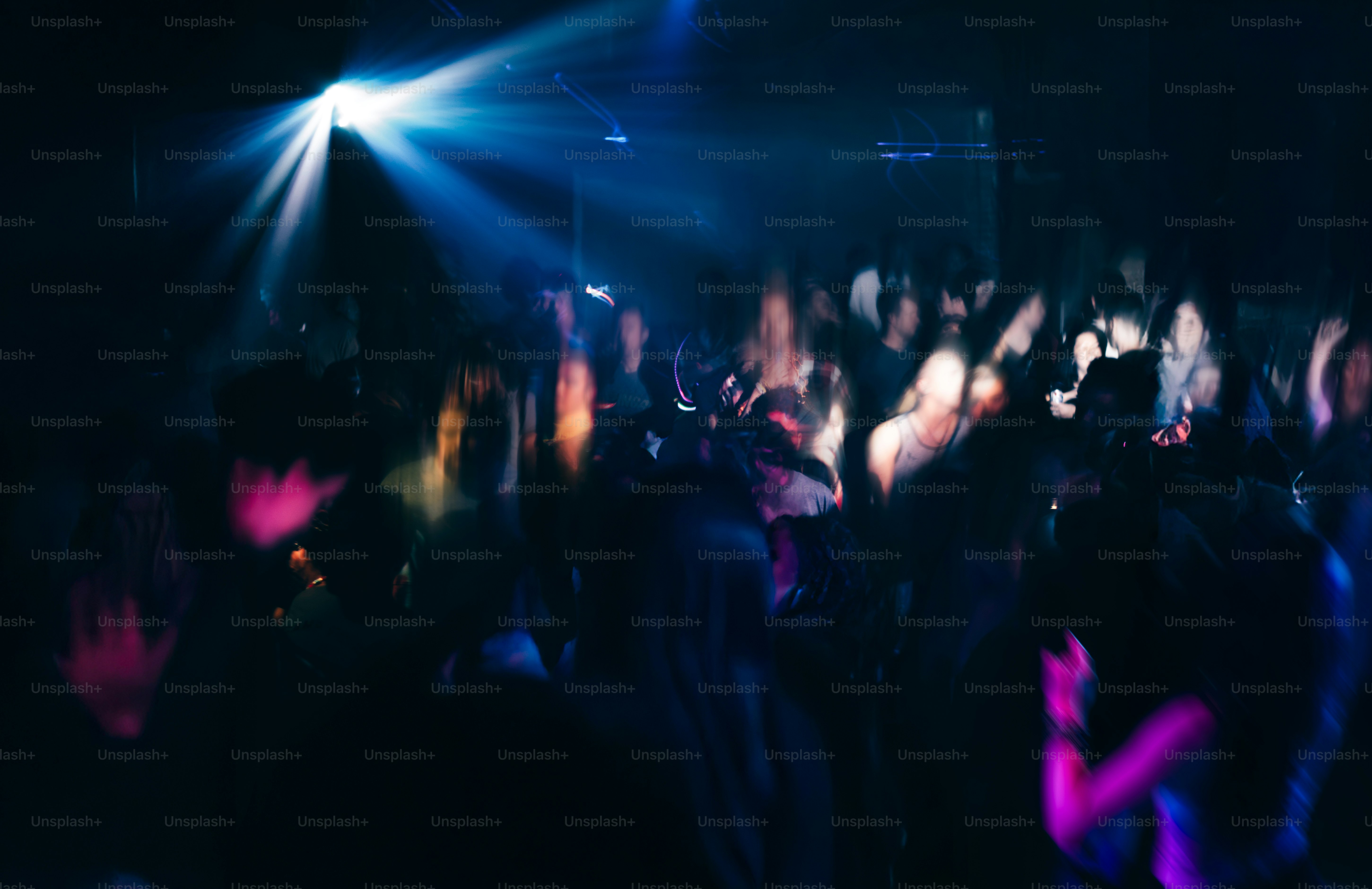 Crowd dancing under blue and purple lights
