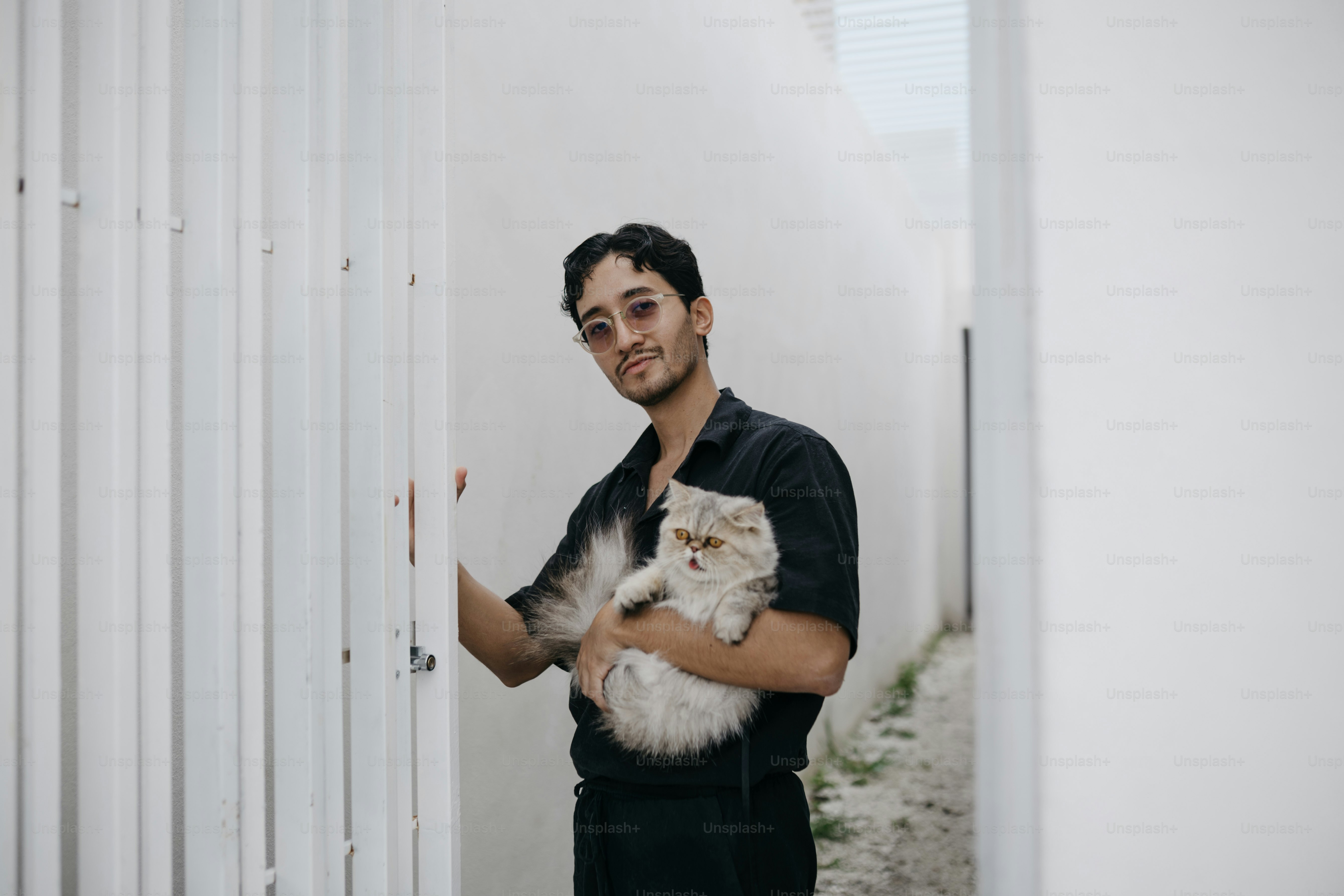 Young man holding a fluffy cat outdoors