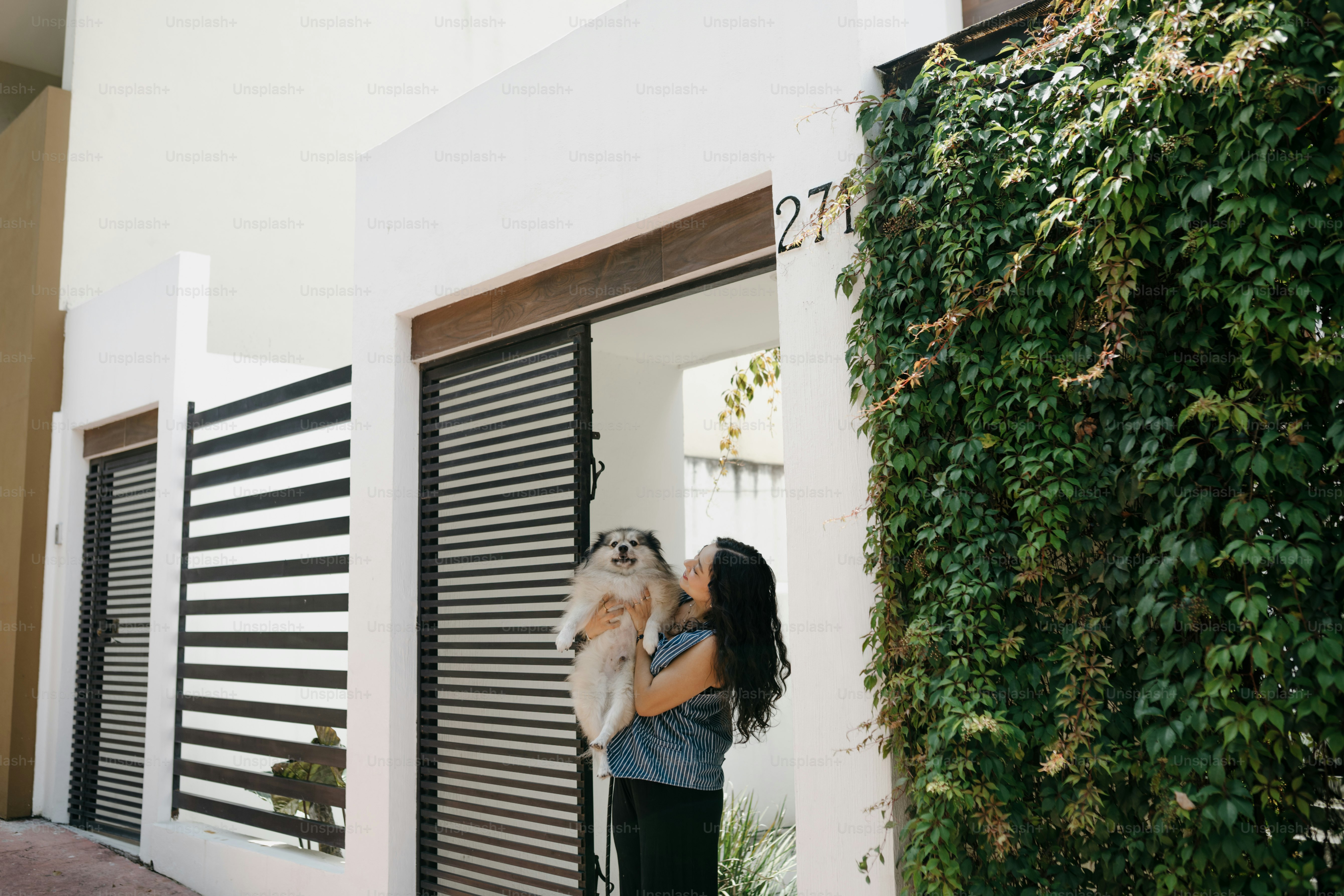 Mujer joven sosteniendo un perro esponjoso al aire libre foto – Imagen ...