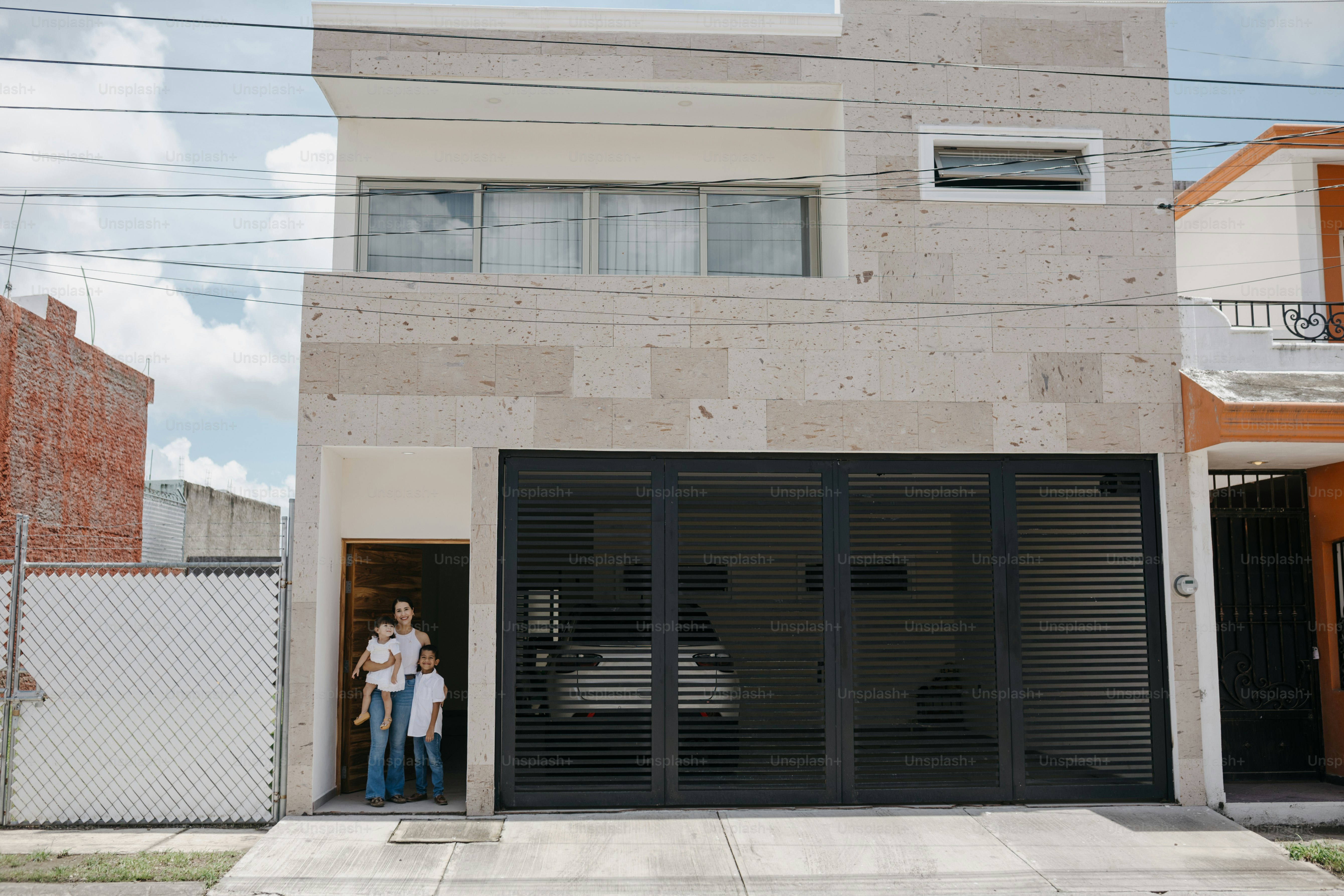 Parents and adult children standing together at the entrance of a modern house
