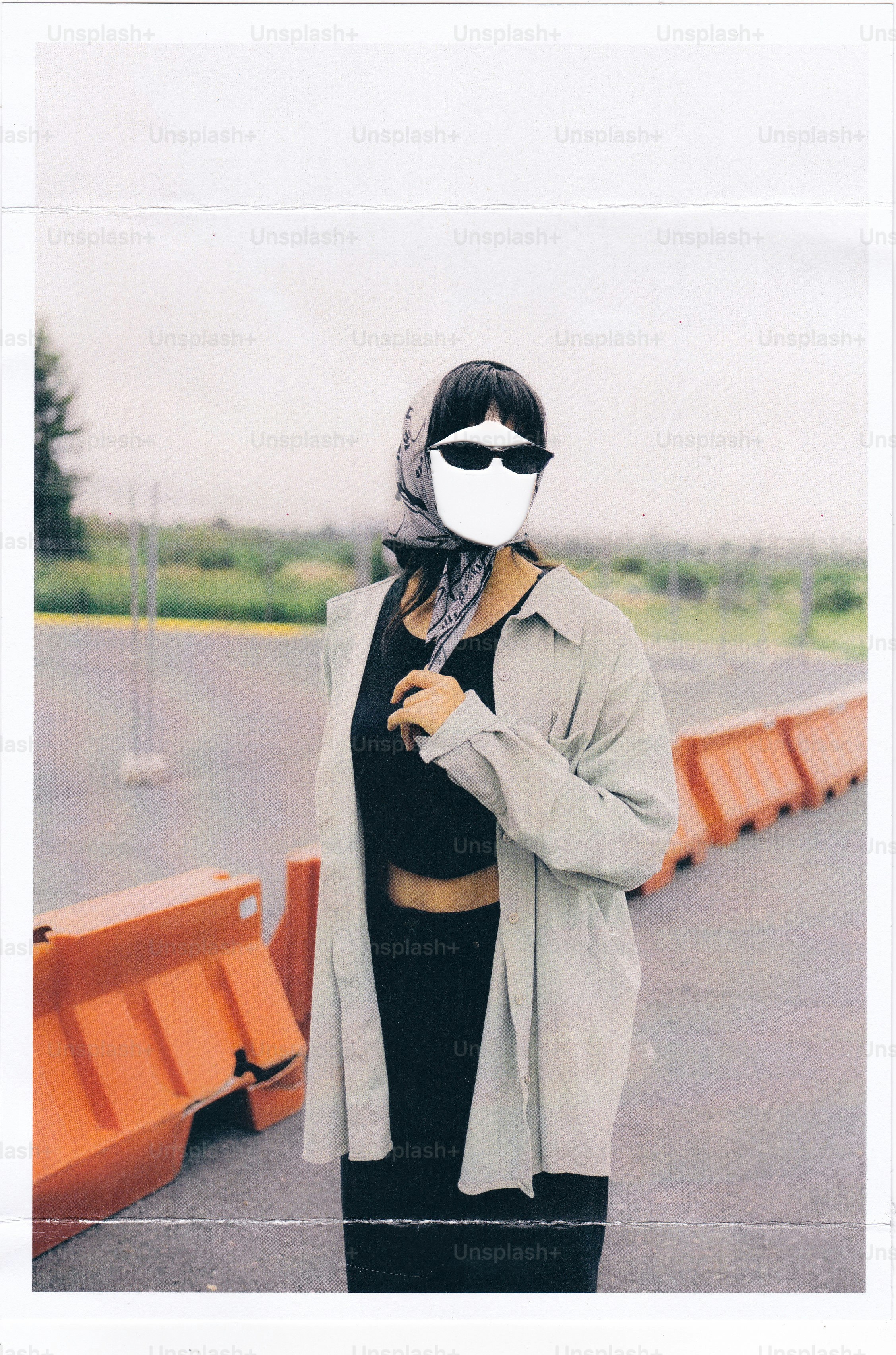 Woman wearing a headscarf and sunglasses outdoors.