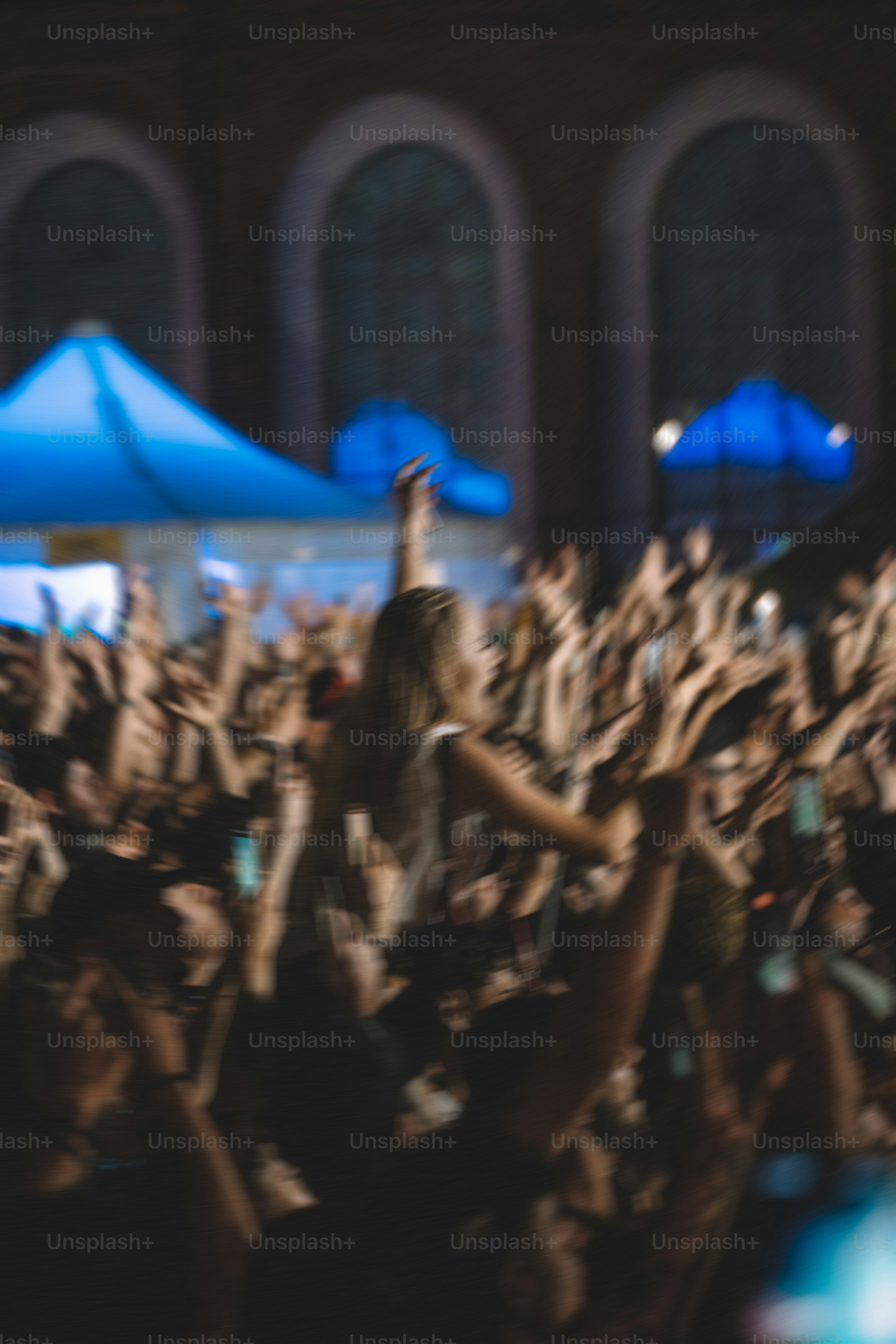 Crowd with hands raised at an outdoor concert.