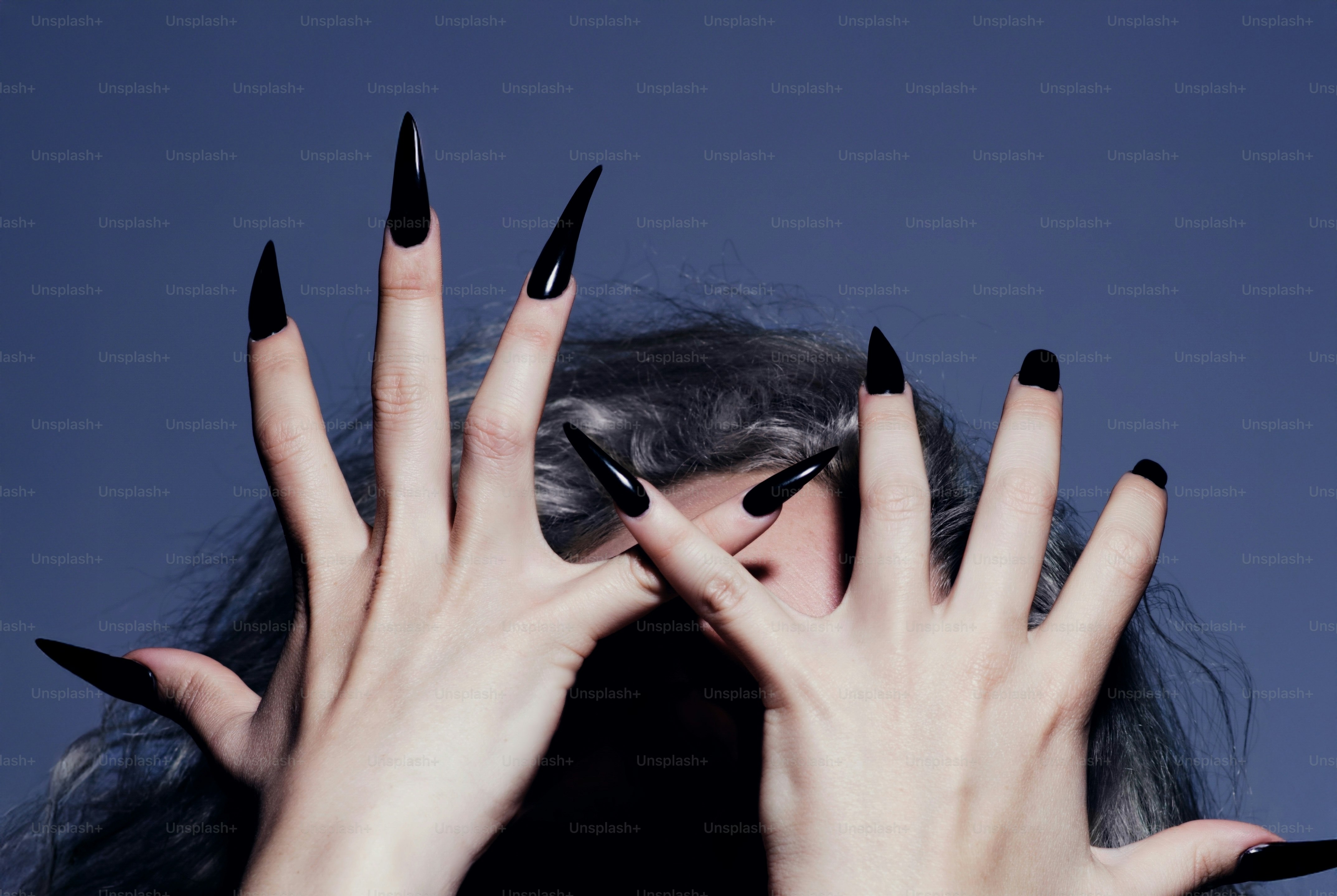 A person with long black pointed nails