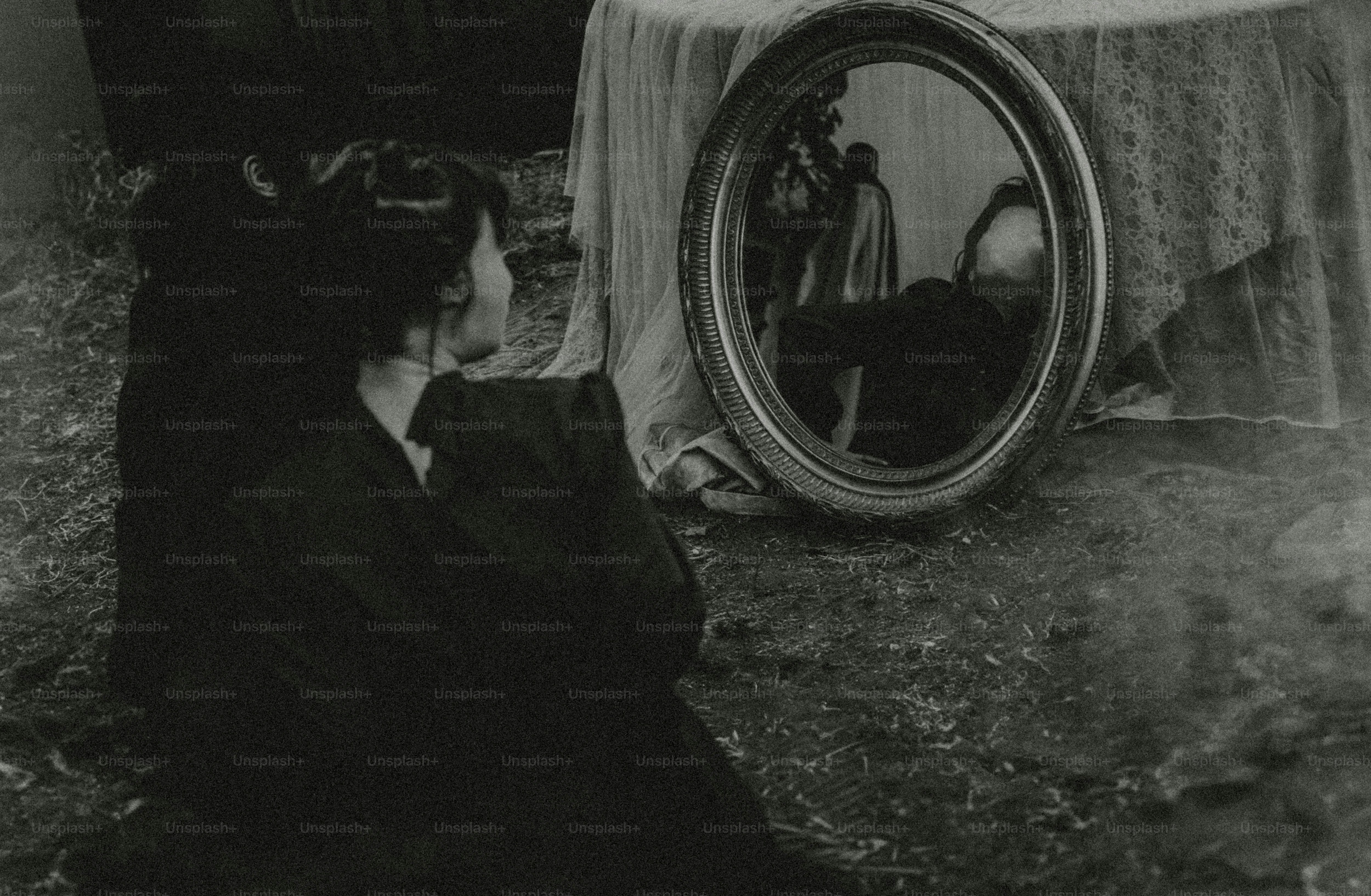 Woman looks at her reflection in an oval mirror.