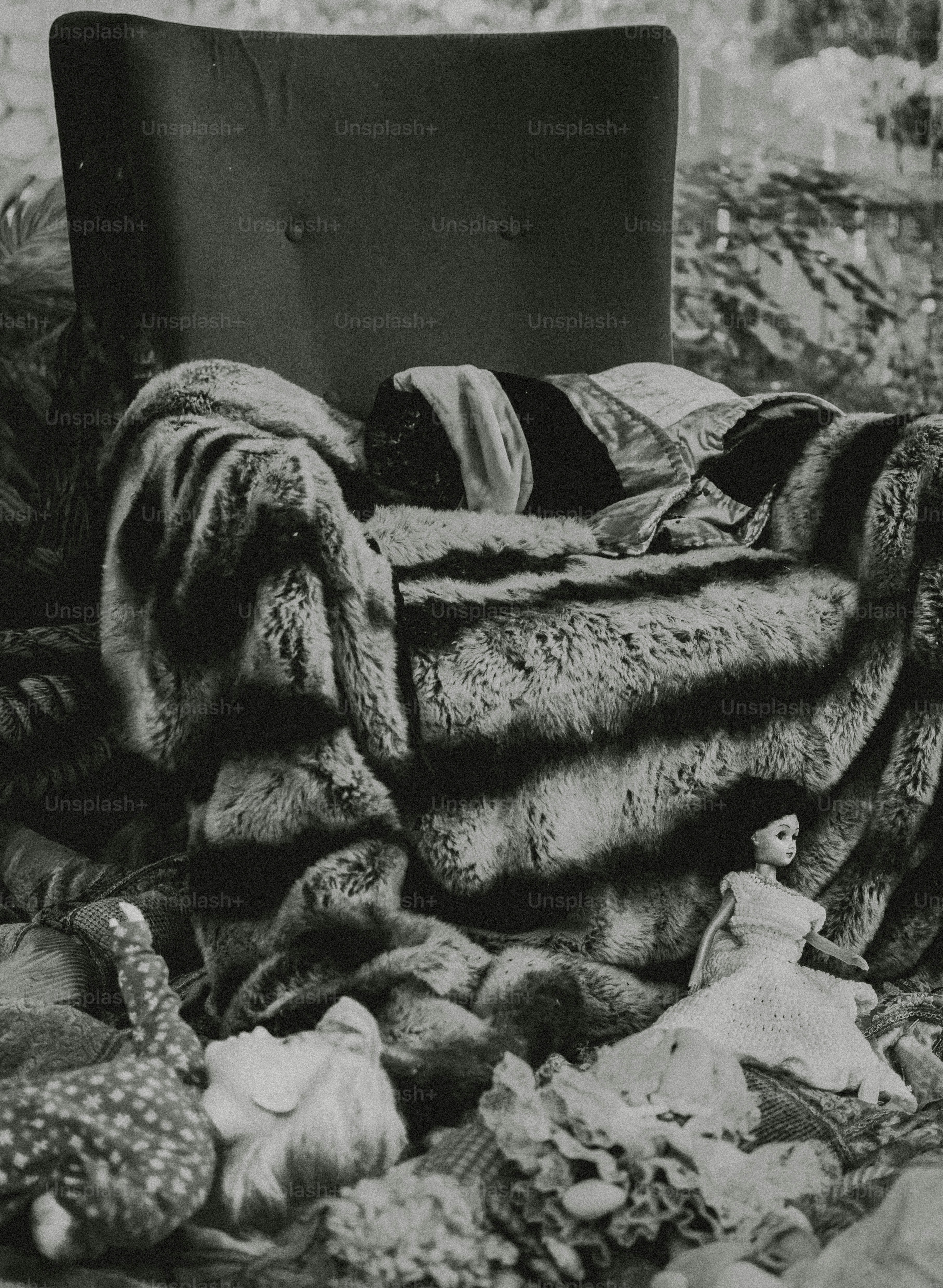 Armchair covered in fur with dolls on the floor.