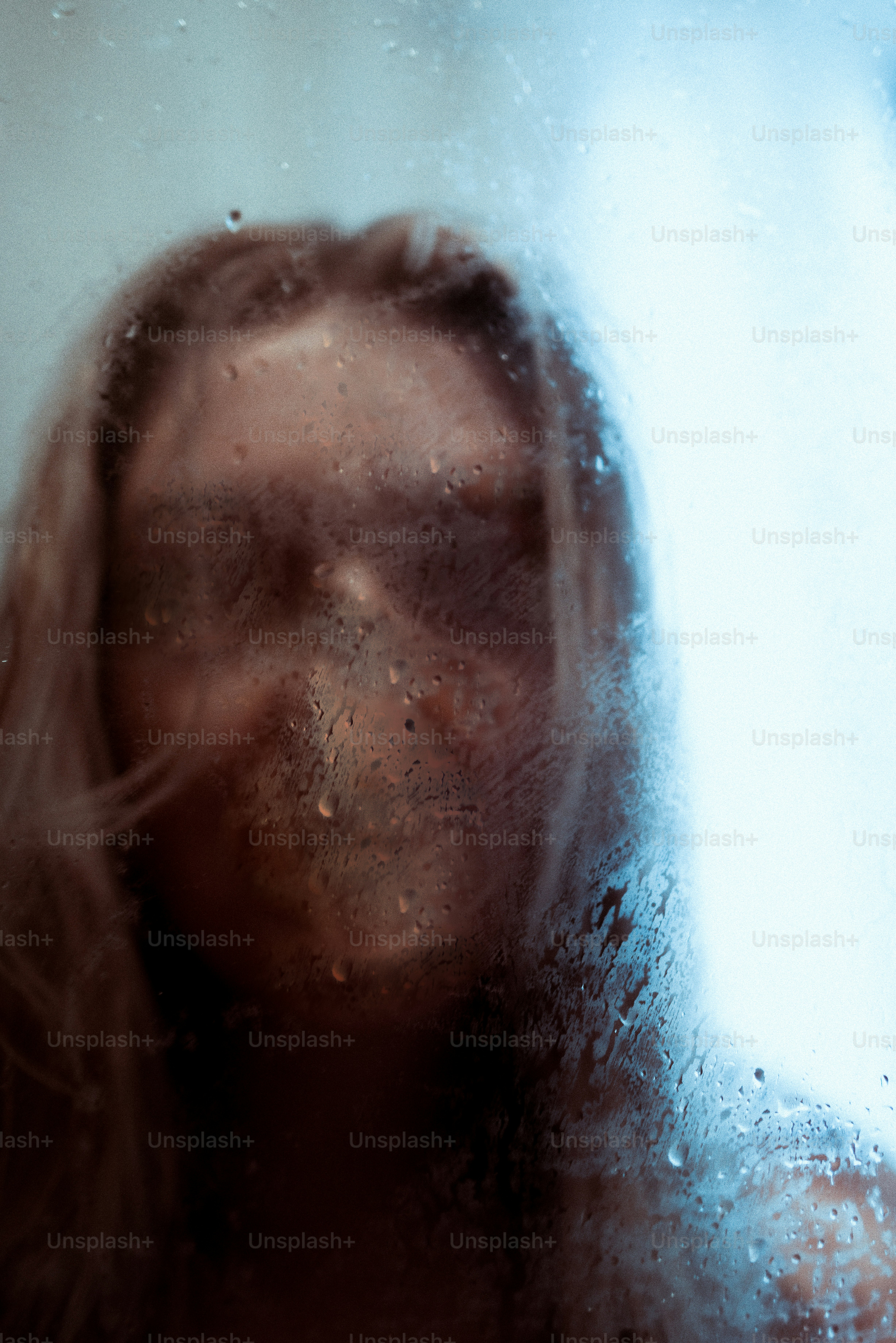 Woman's face seen through steamy glass