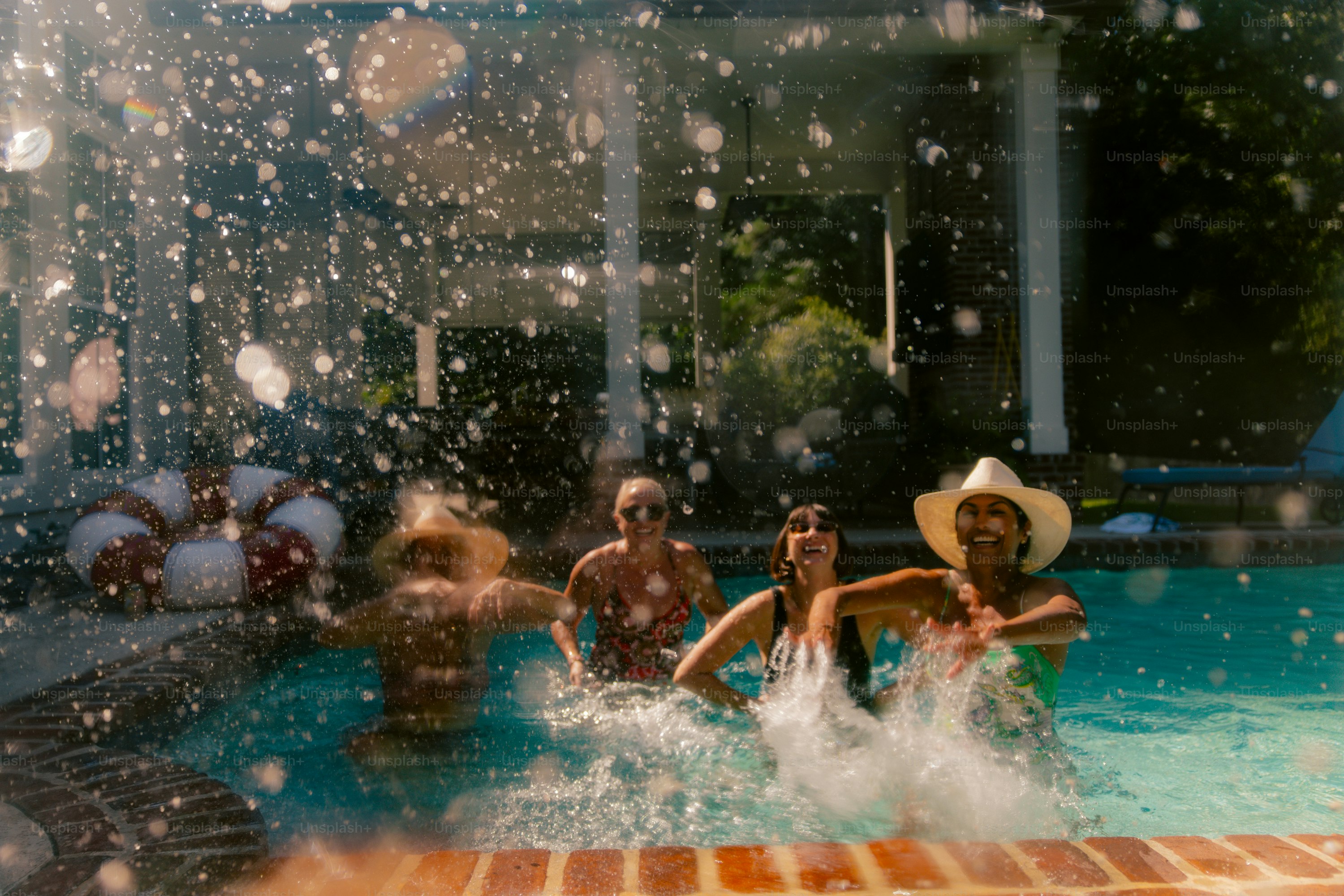 Friends splashing water in a swimming pool