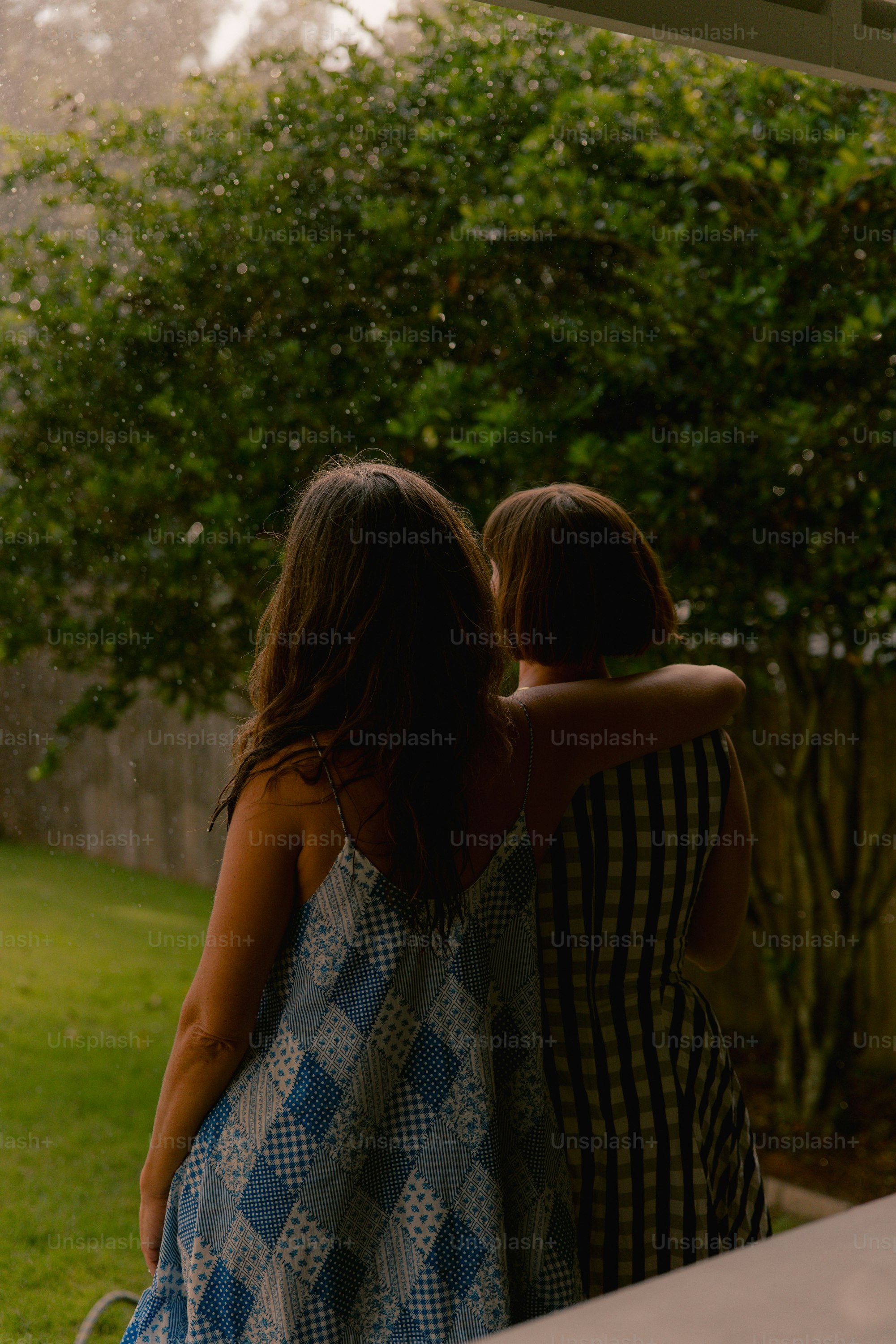 Two women embracing in the rain outdoors. photo – Friends Image on Unsplash