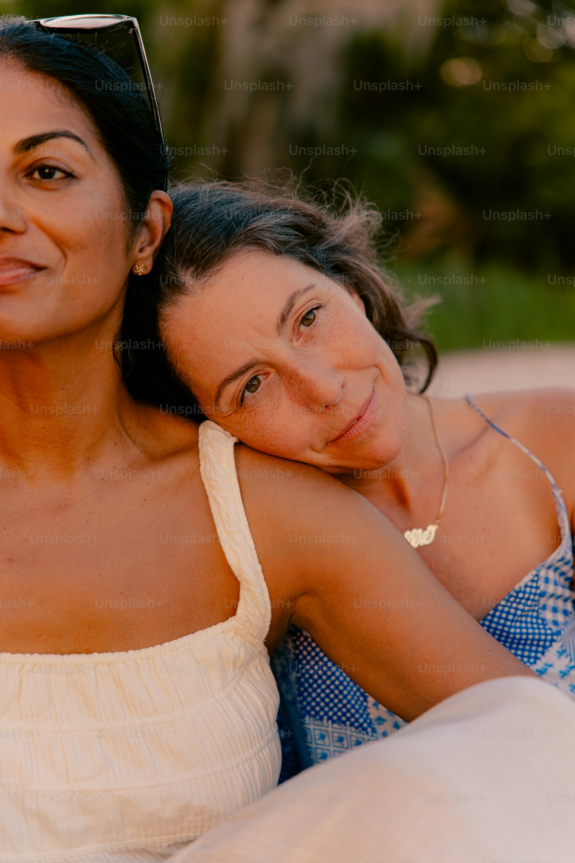 Two women resting their heads on each other