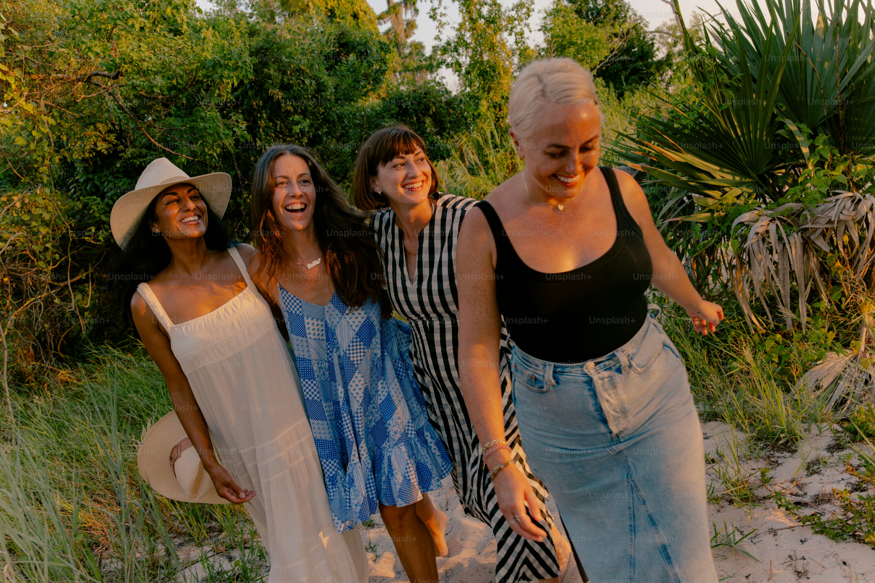 Four women smiling and walking outdoors