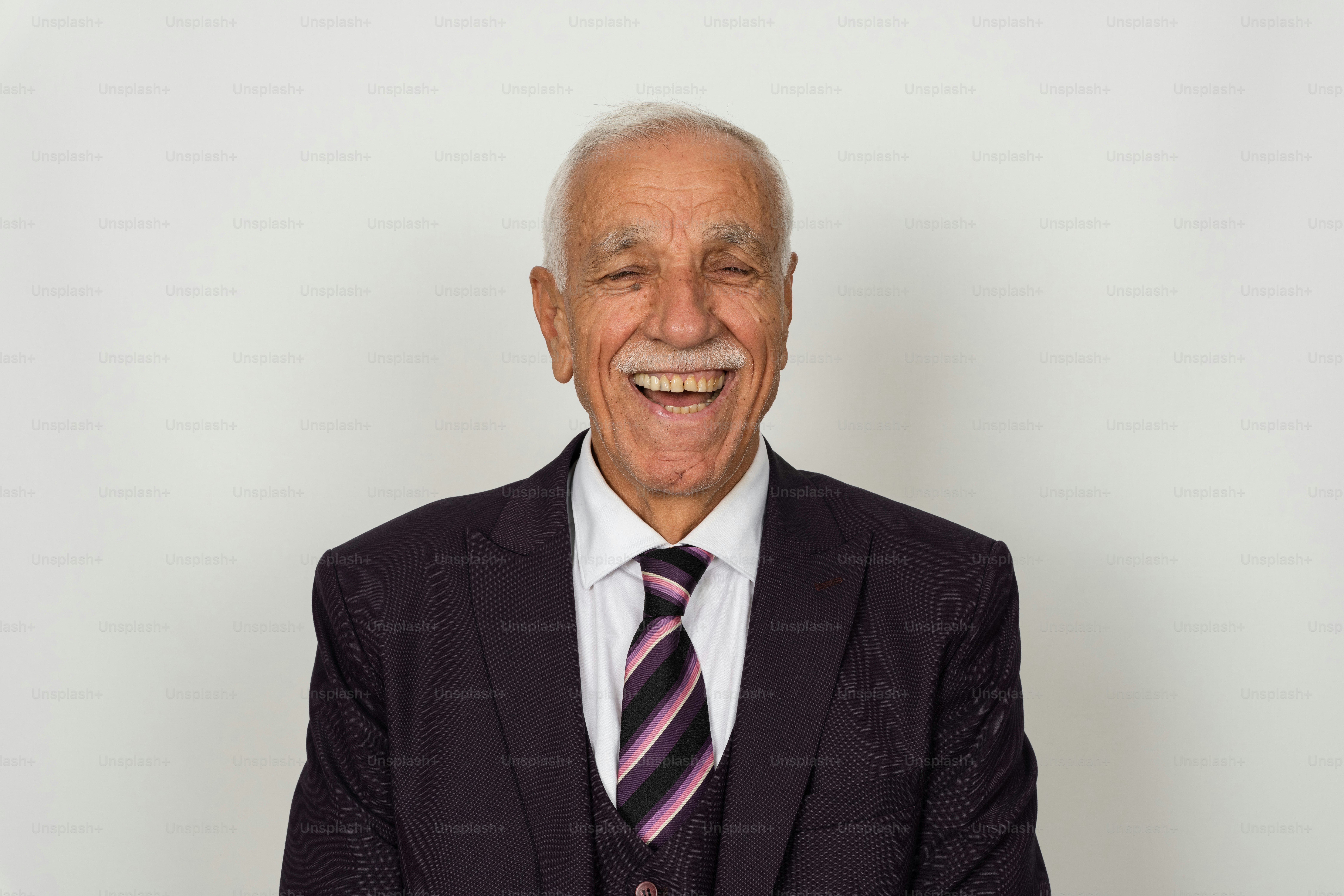 Homem idoso em um terno rindo com vontade