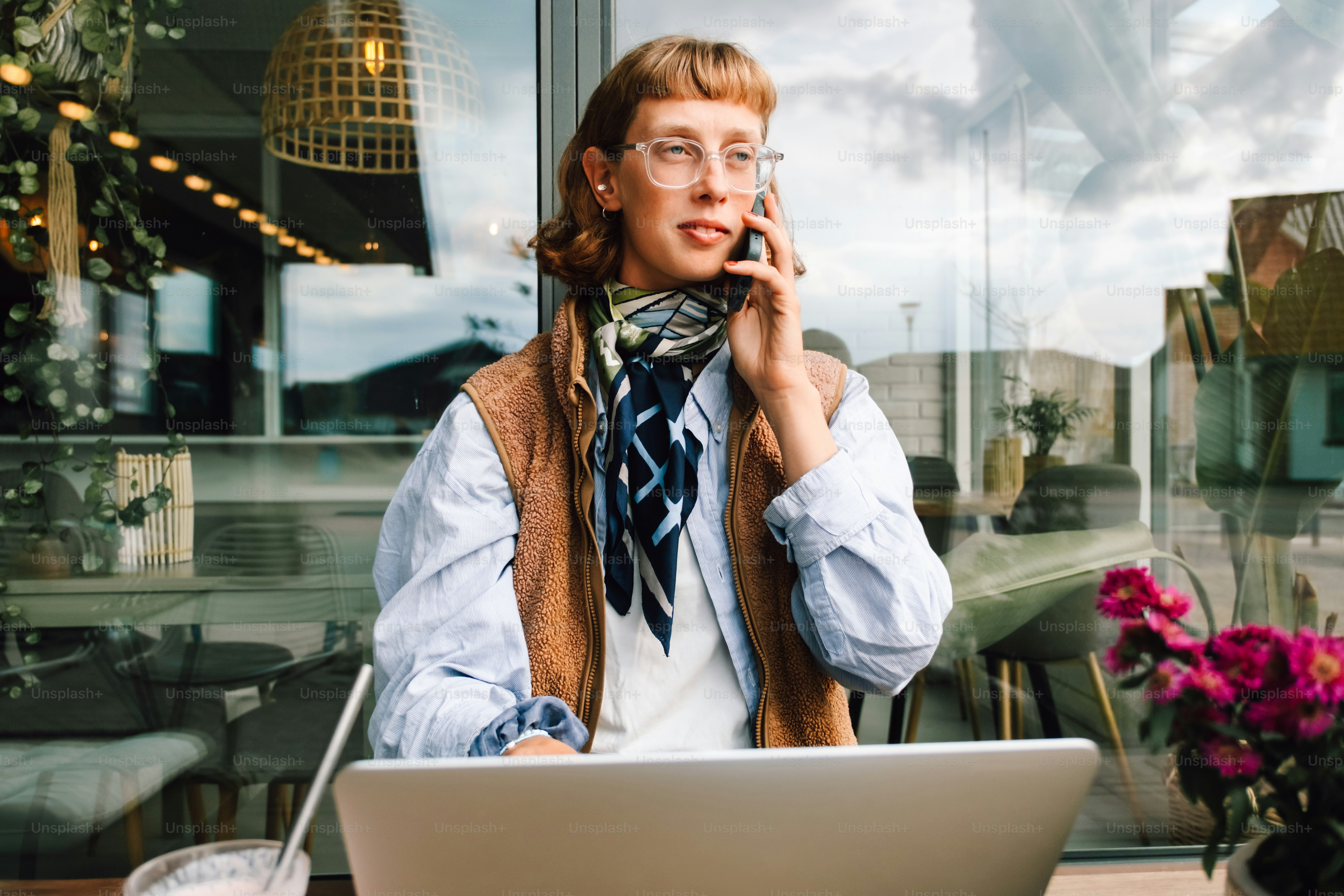Mulher no telefone com laptop na mesa