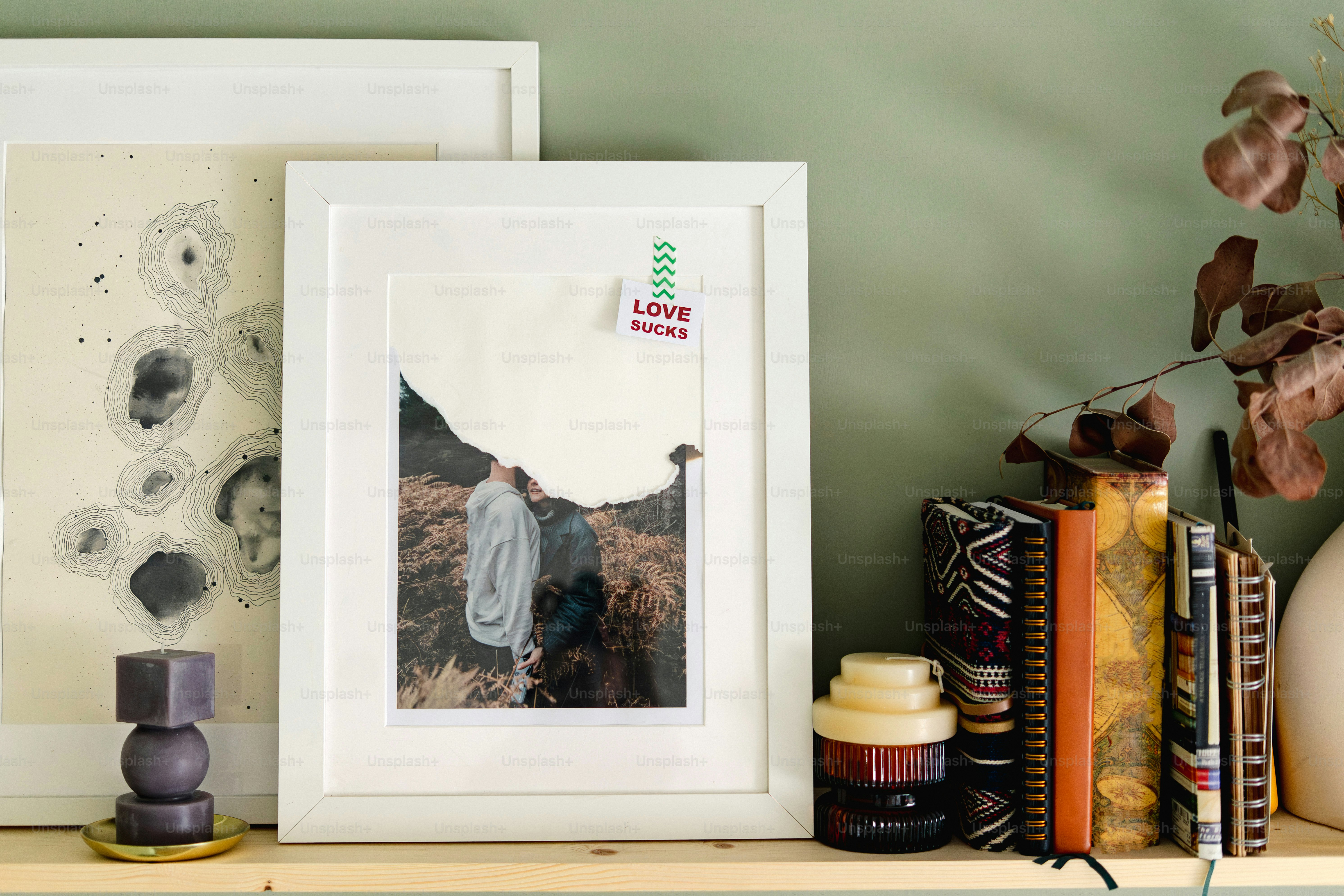 Framed artwork and books on a shelf
