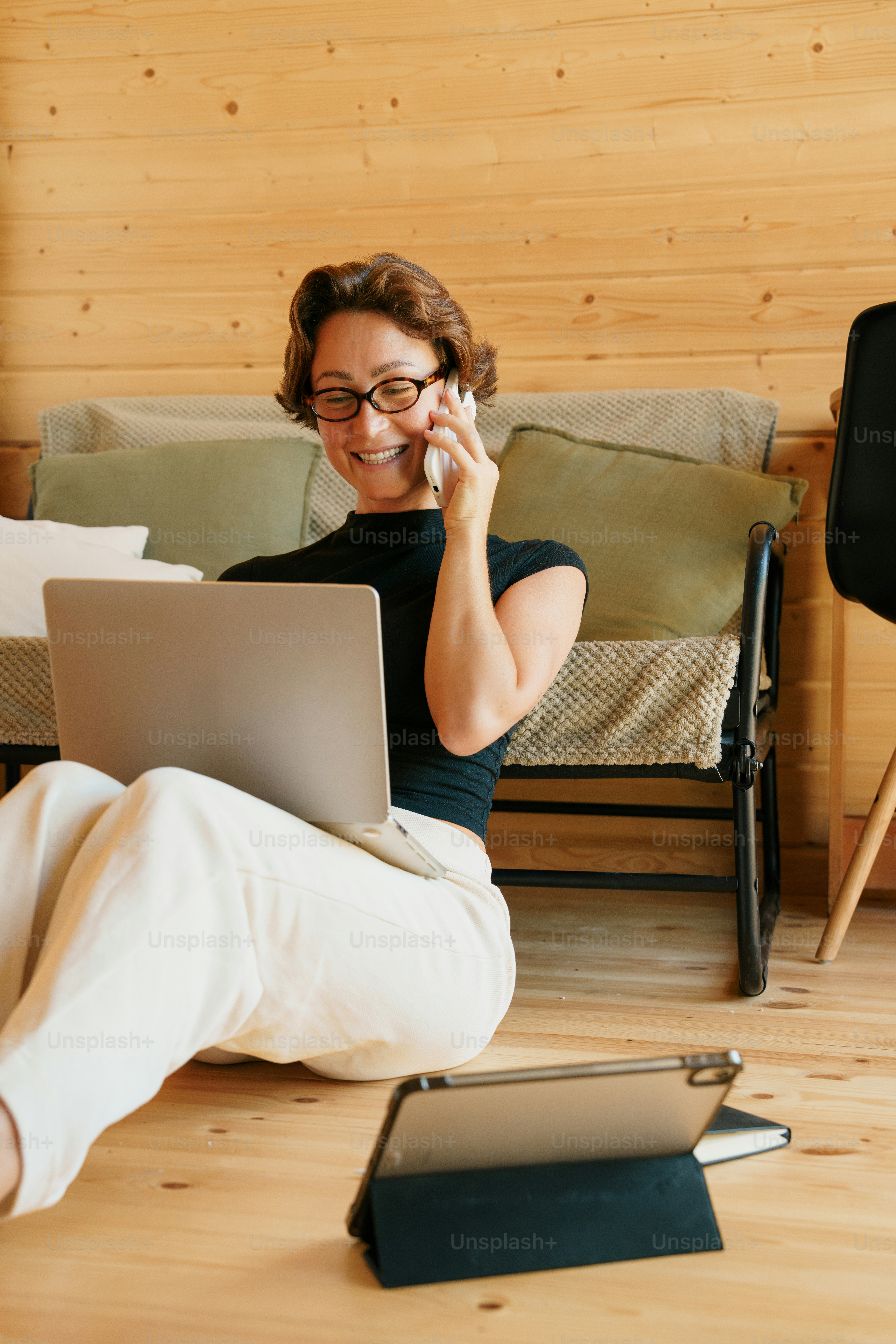 Woman talking on phone with laptop and tablet