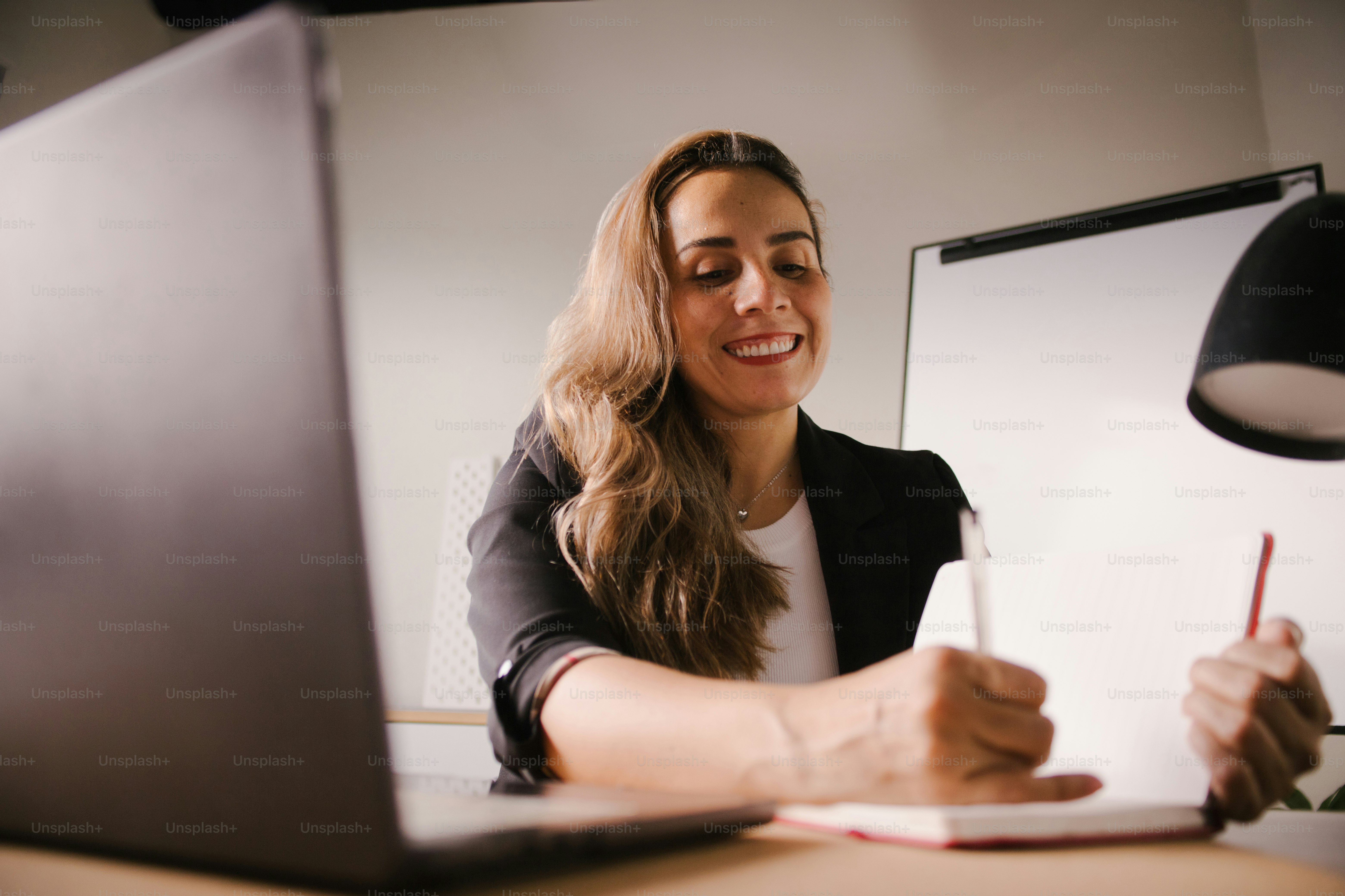 Woman working at a desk with laptop and notebook. photo – Female Image ...