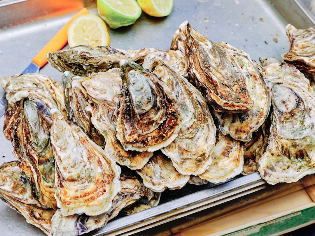 A pile of fresh oysters with lemon slices