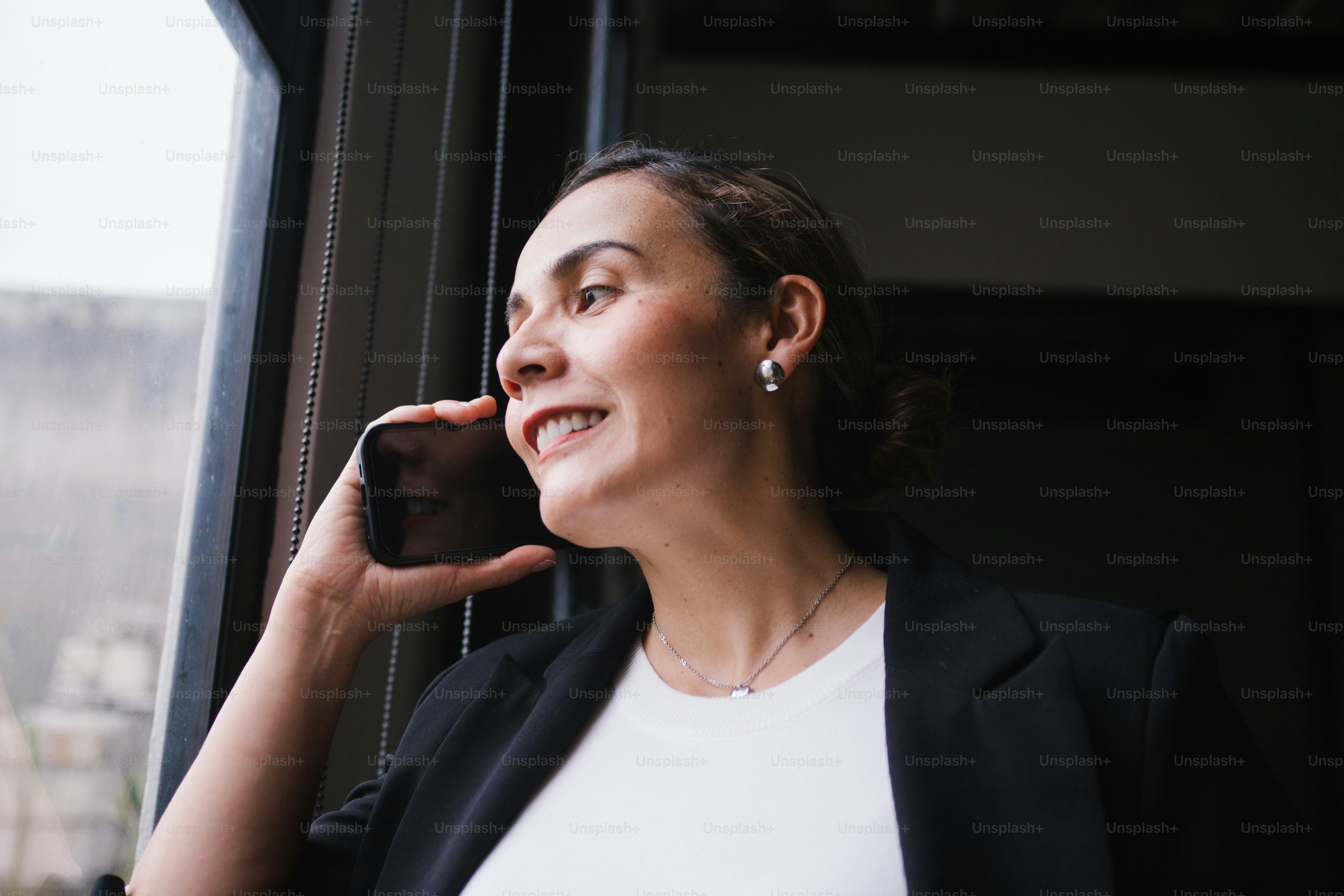A woman in a suit talks on her phone.