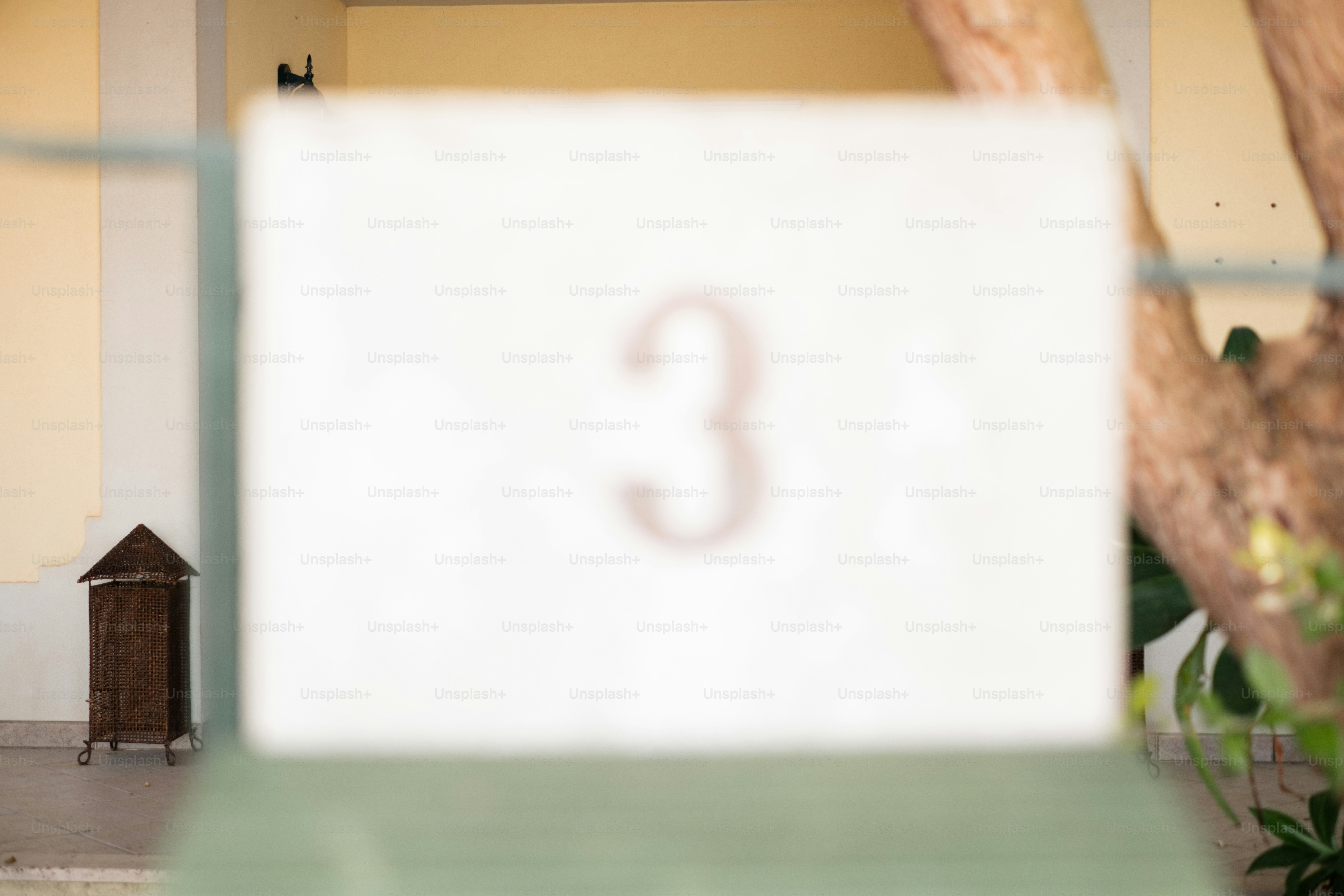 Un letrero blanco con el número tres.