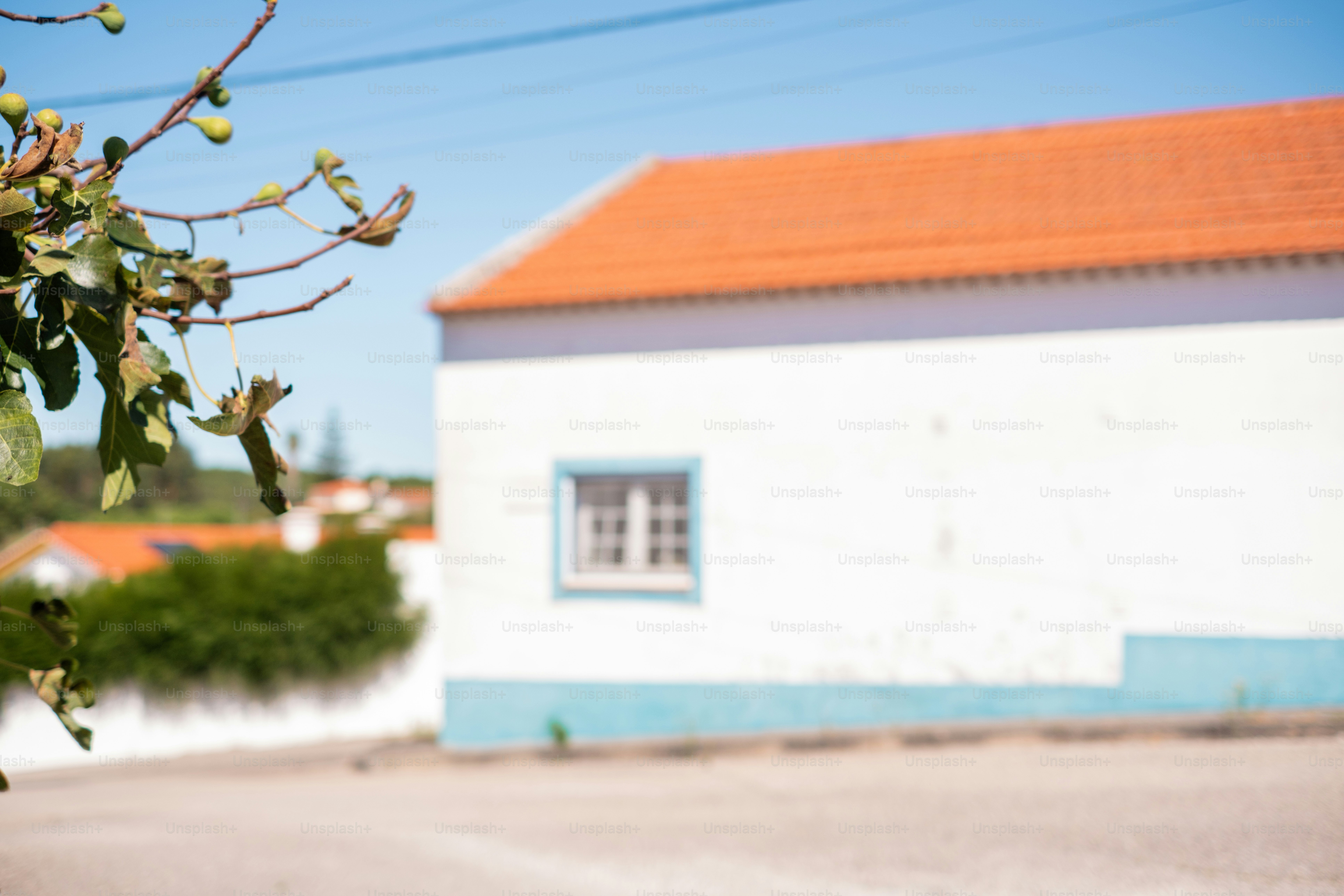 Edificio blanco con techo y ventana naranja.