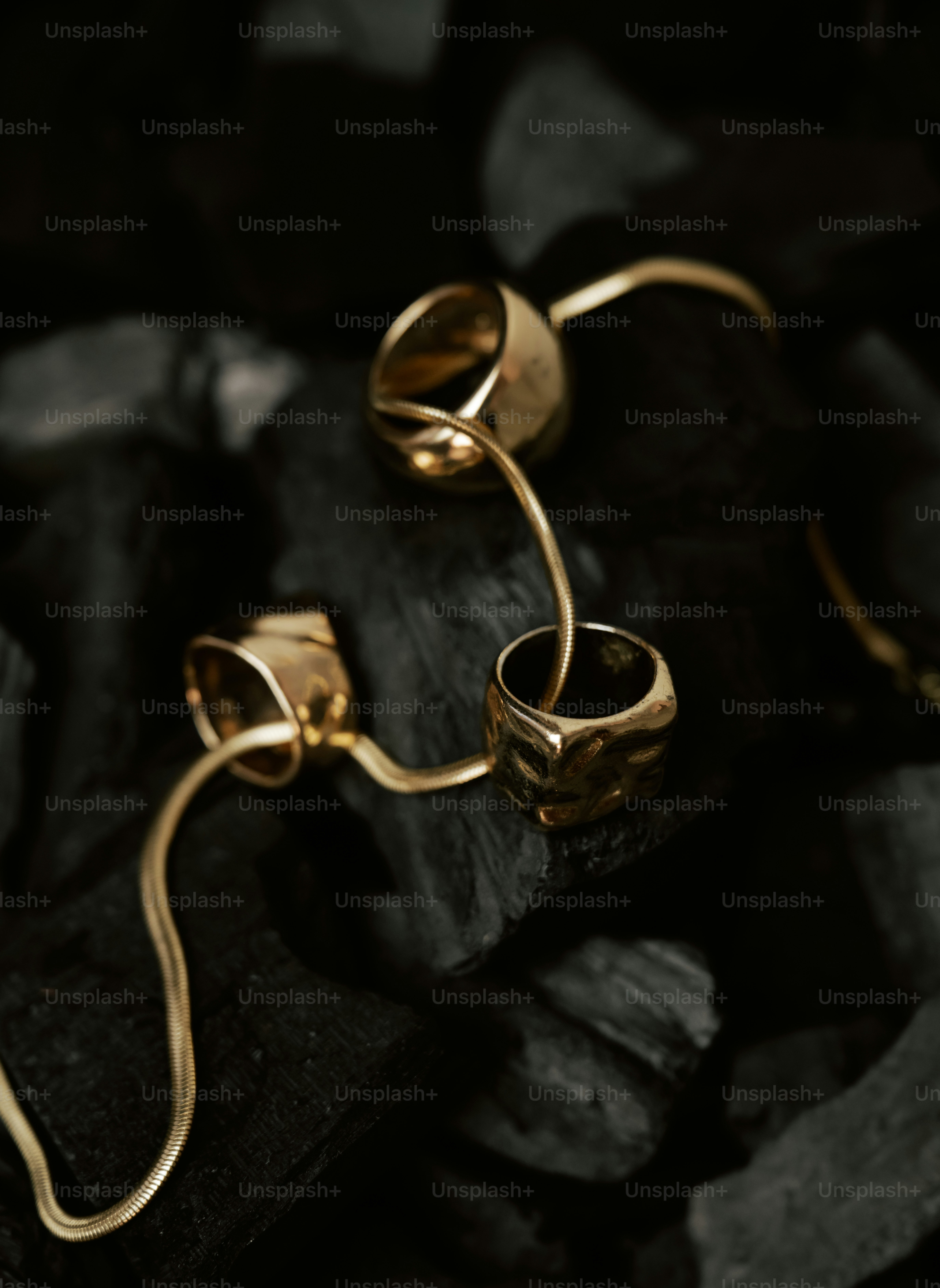 Gold jewelry on black charcoal background.