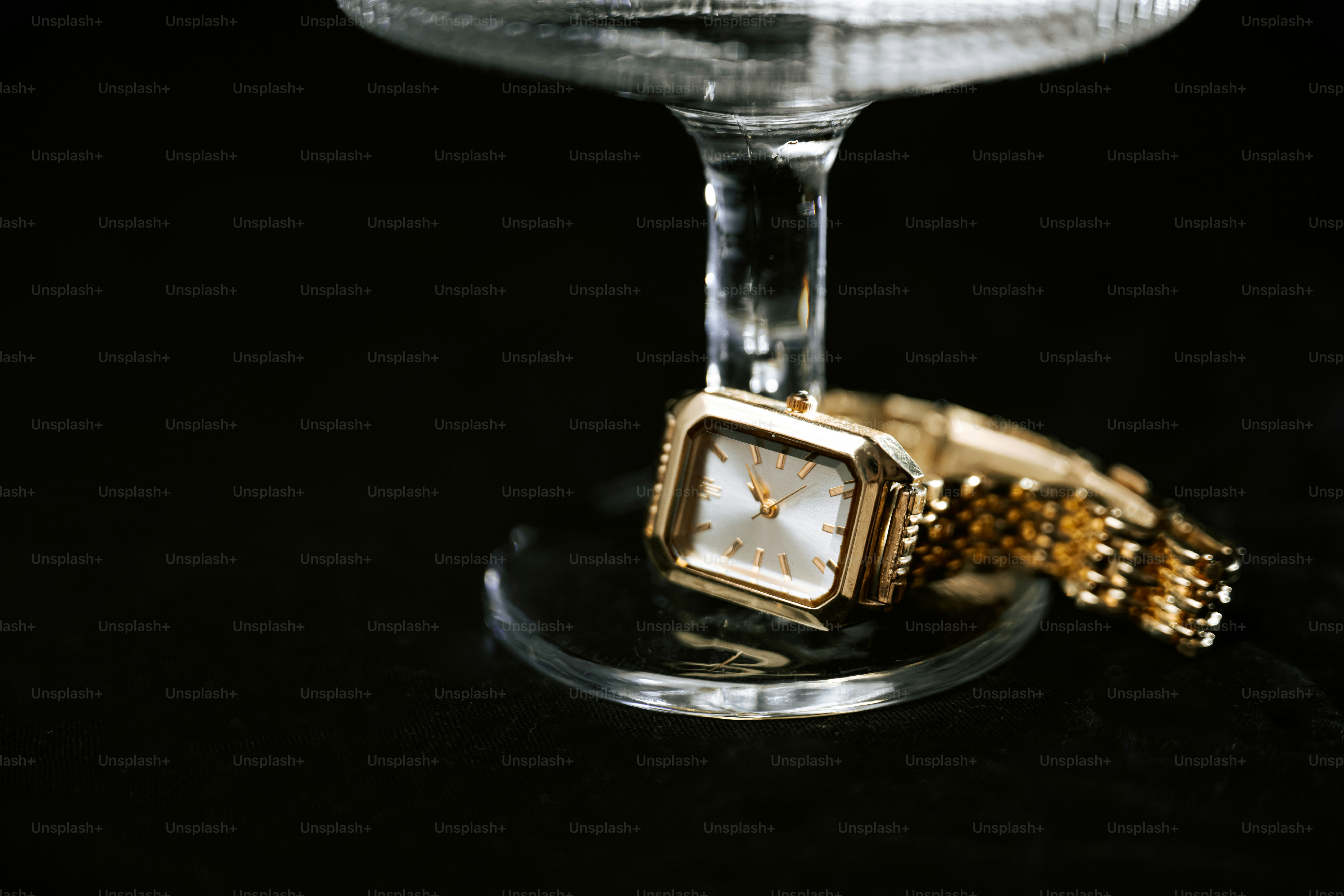 Gold watch resting on a glass stem