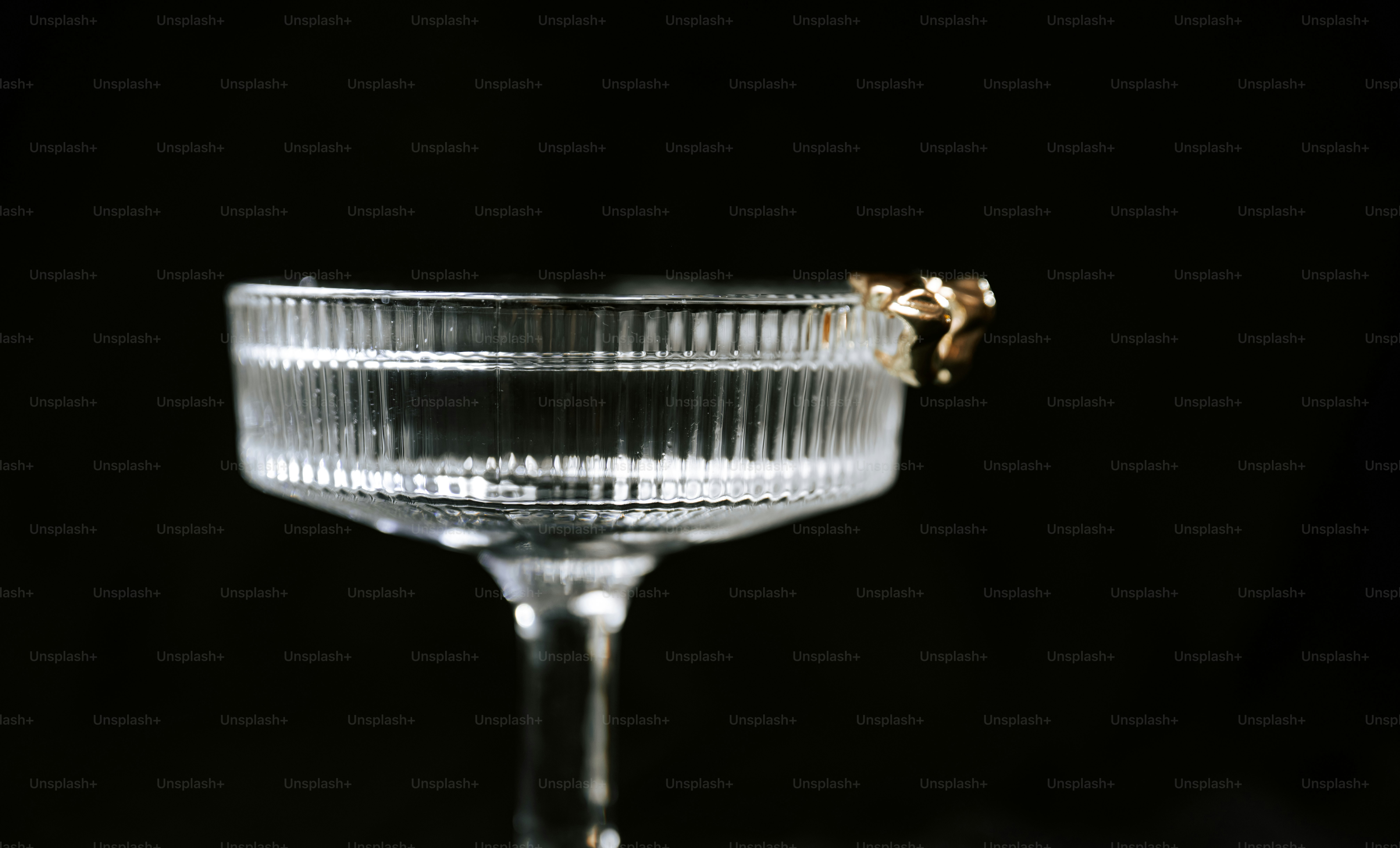 A cocktail glass with a gold ring on rim