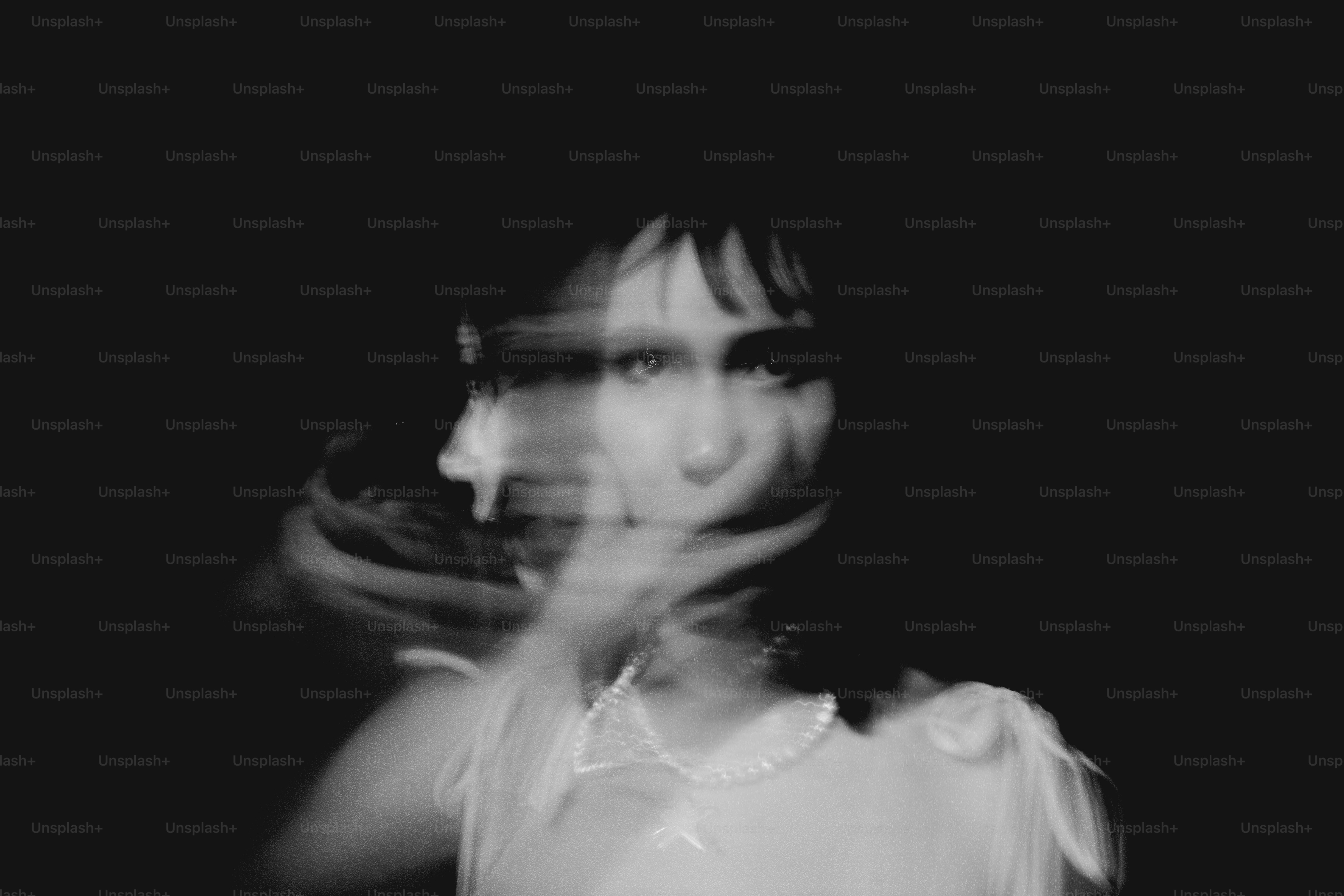 Blurred portrait of a woman against a dark background.