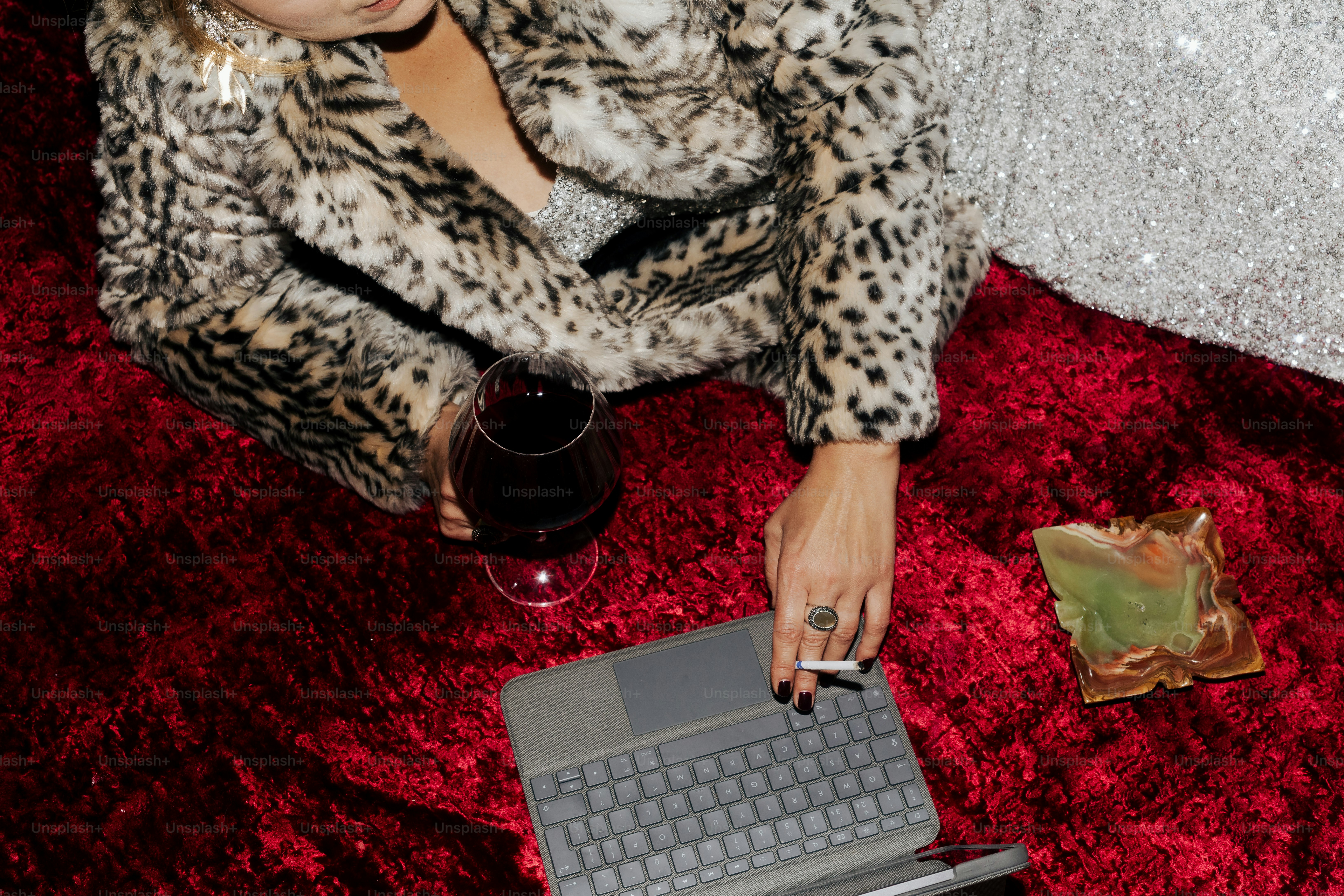 Woman in leopard coat with wine and cigarette