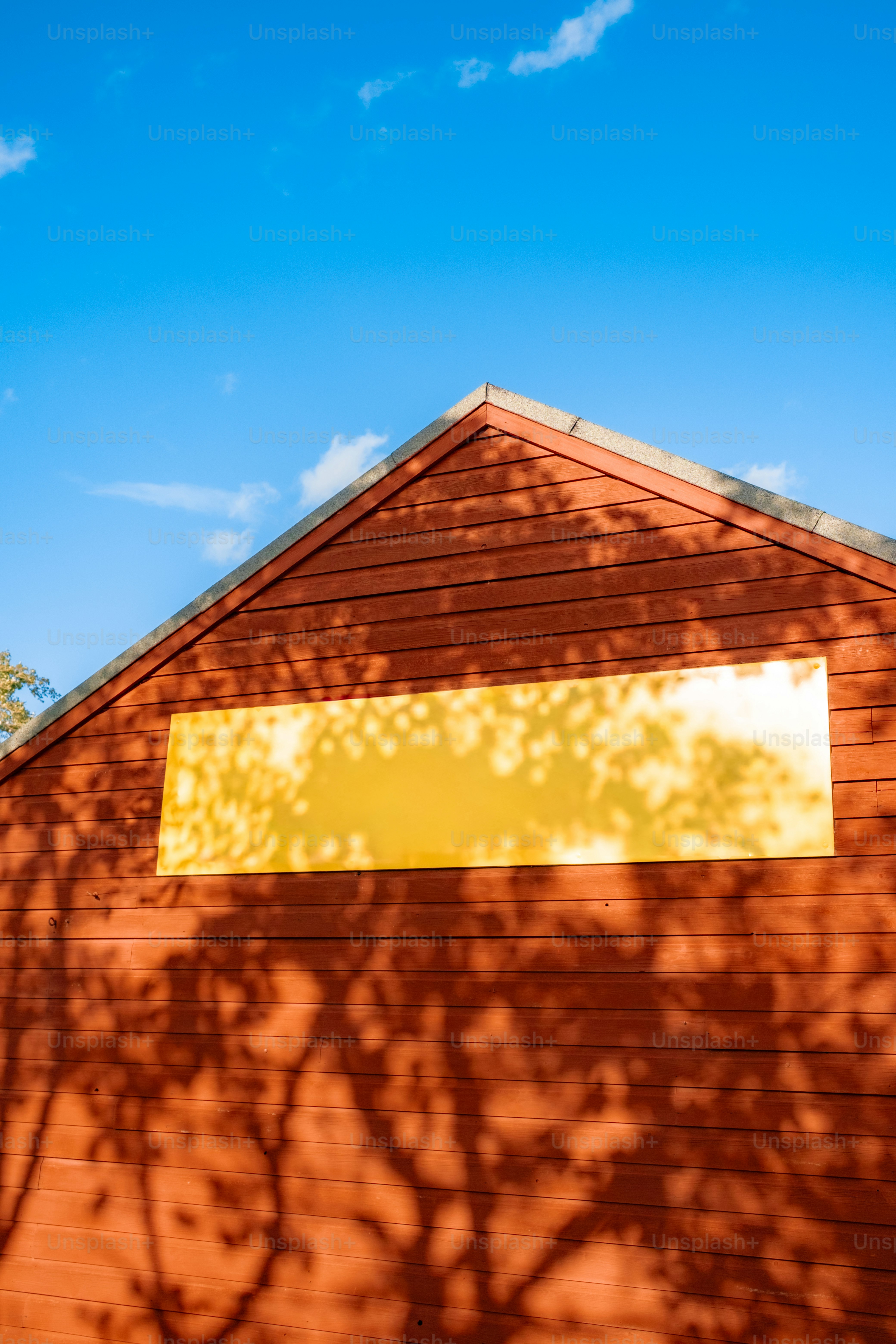 Wooden building with yellow sign and tree shadows. photo – Outdoor ...