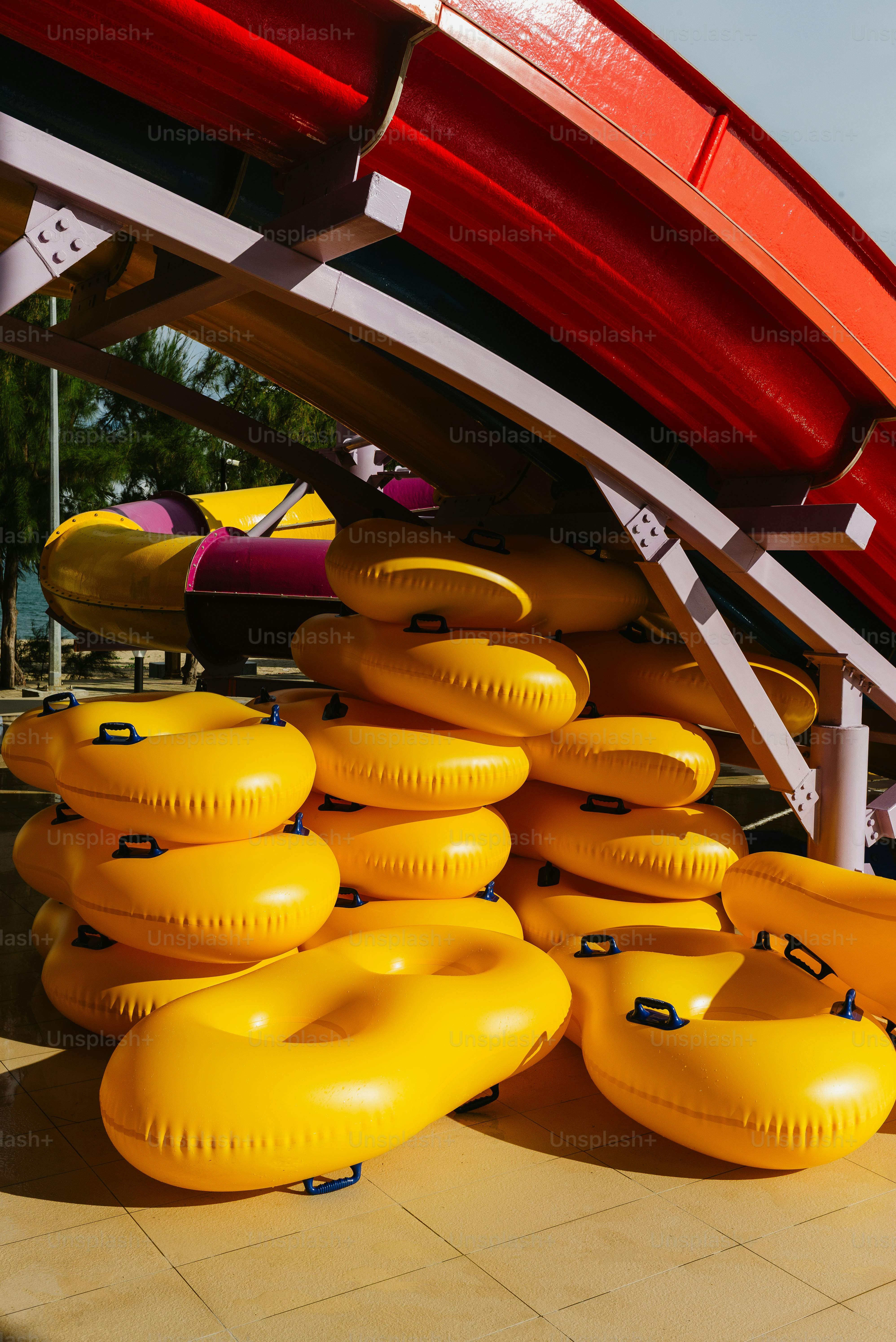 Stack of yellow inflatable tubes at water park. photo – Fun Image on ...