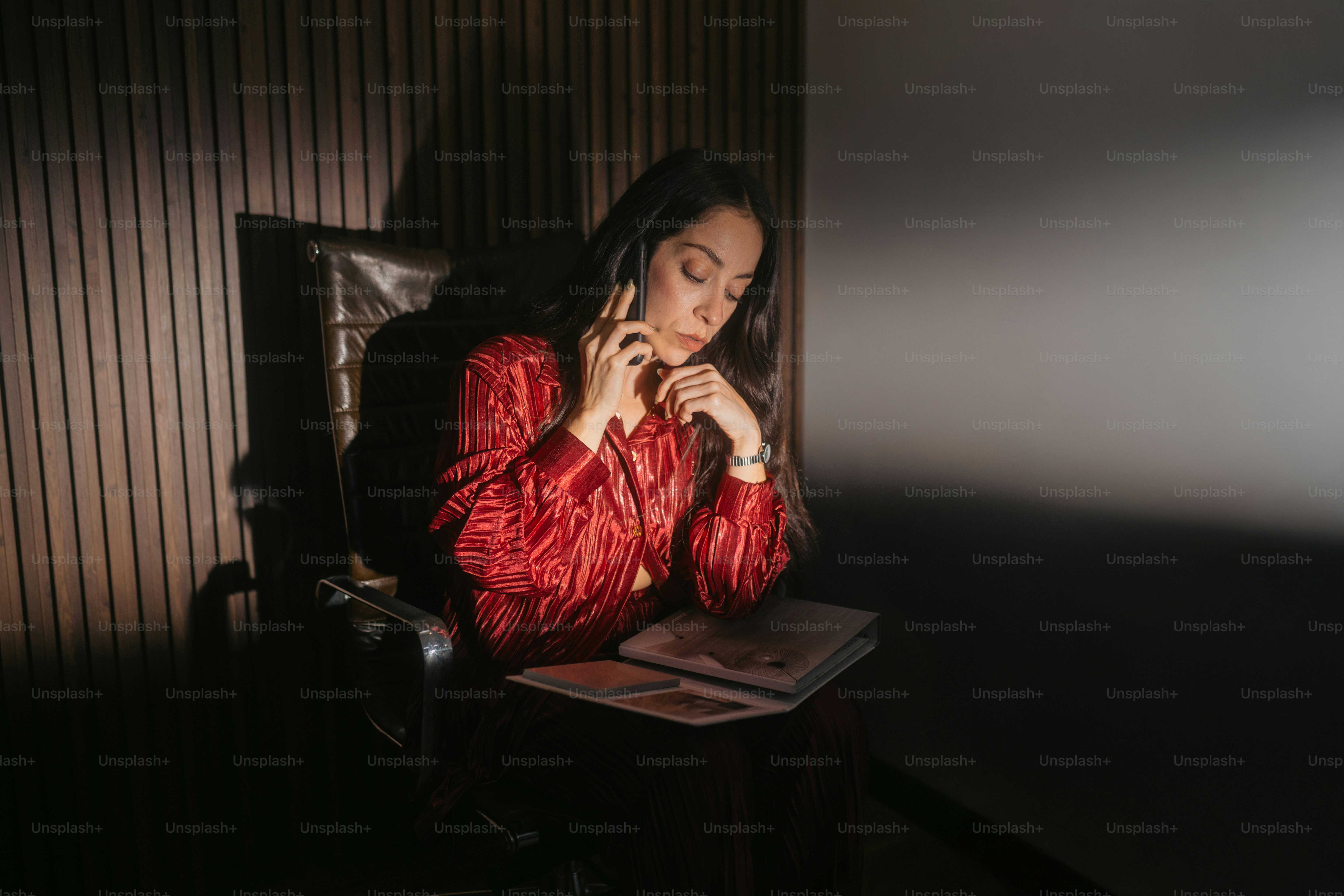 Woman in red dress talking on phone in chair