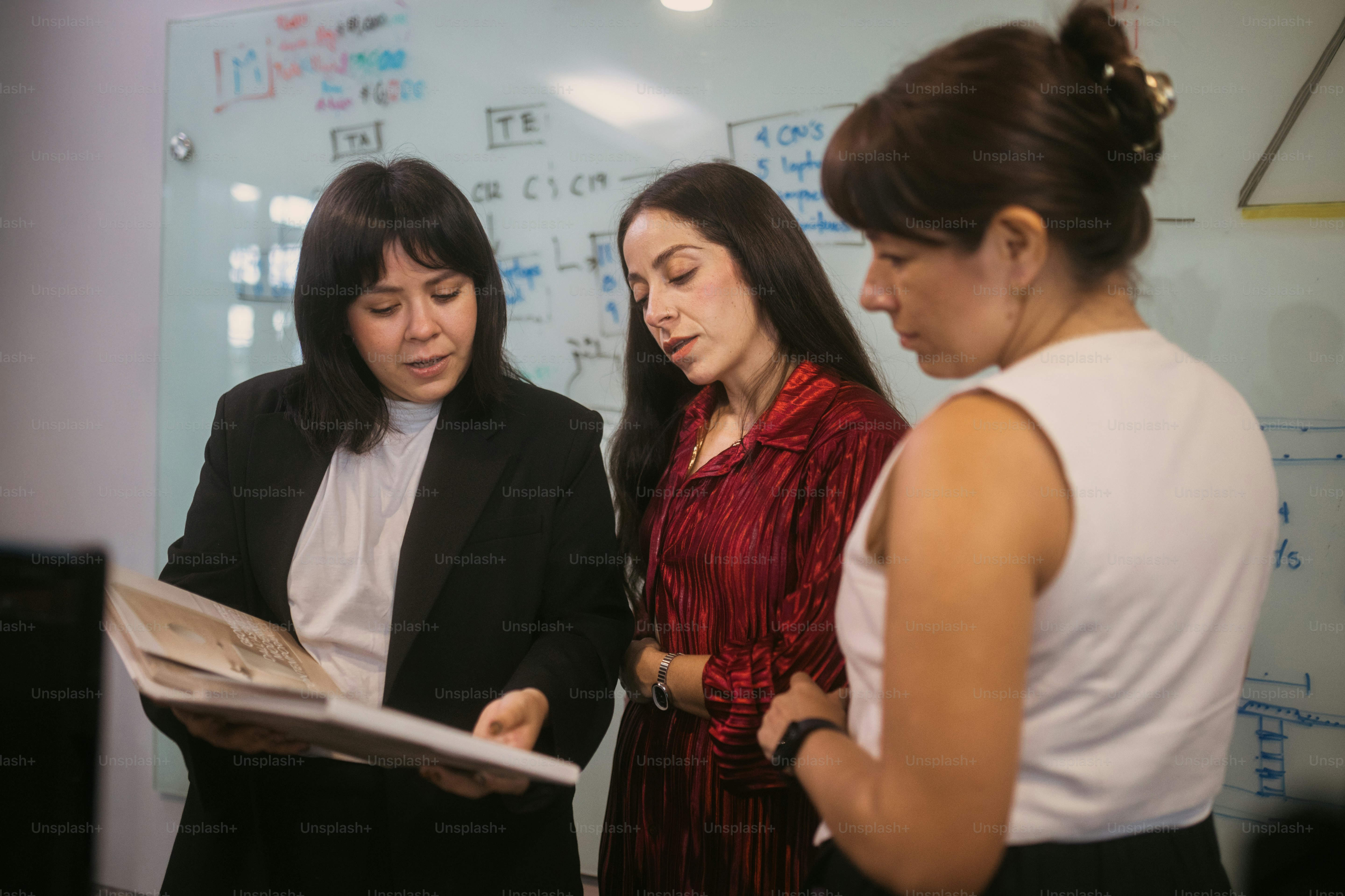Researchers collaborating at a whiteboard in a modern office