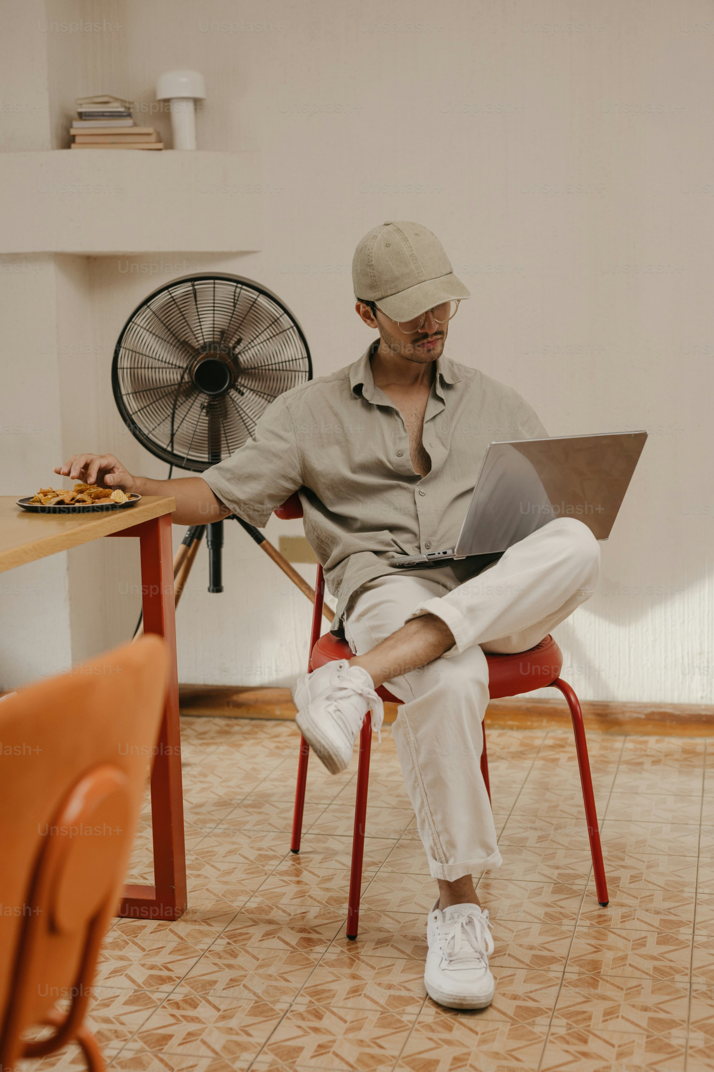 Man in cap working on laptop at table
