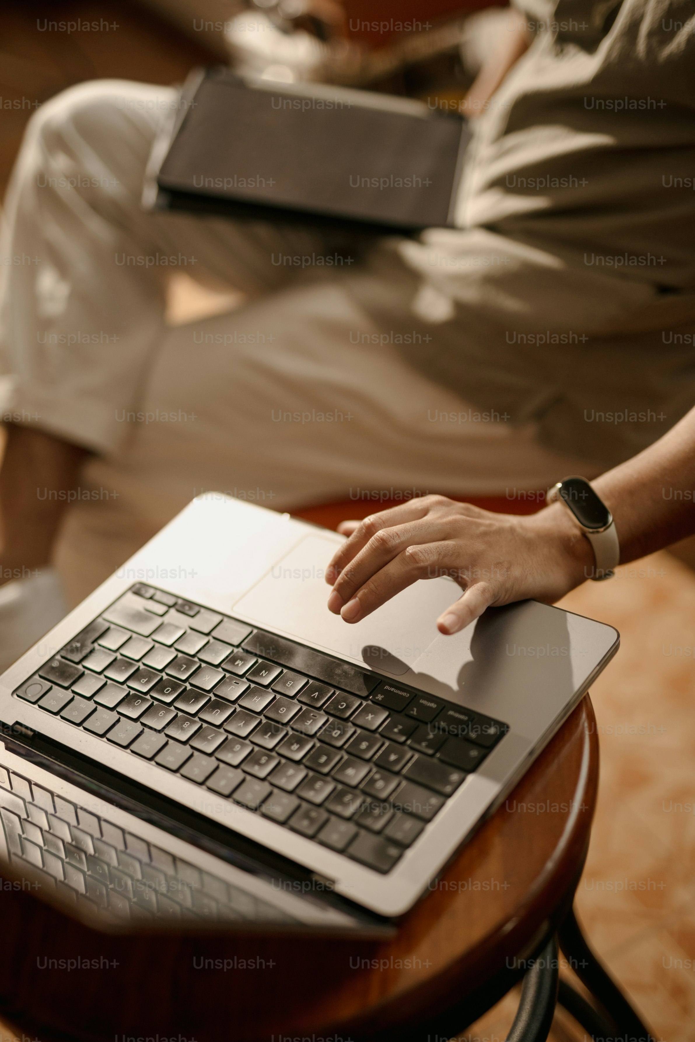 Person using a laptop and tablet indoors.