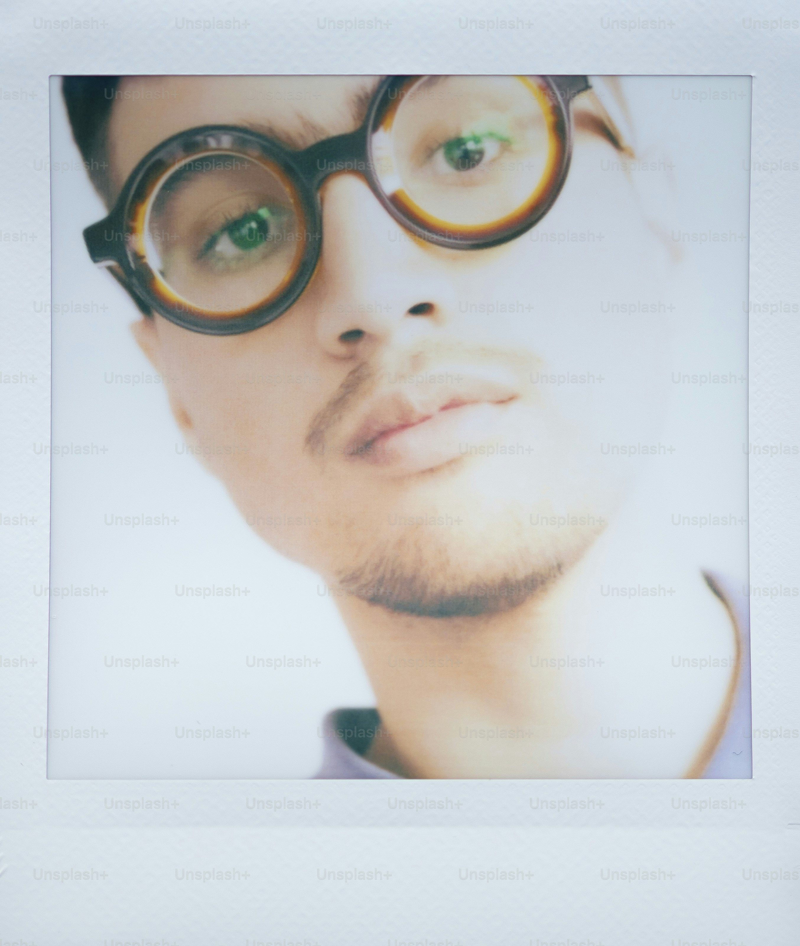 Man wearing round glasses looks into camera