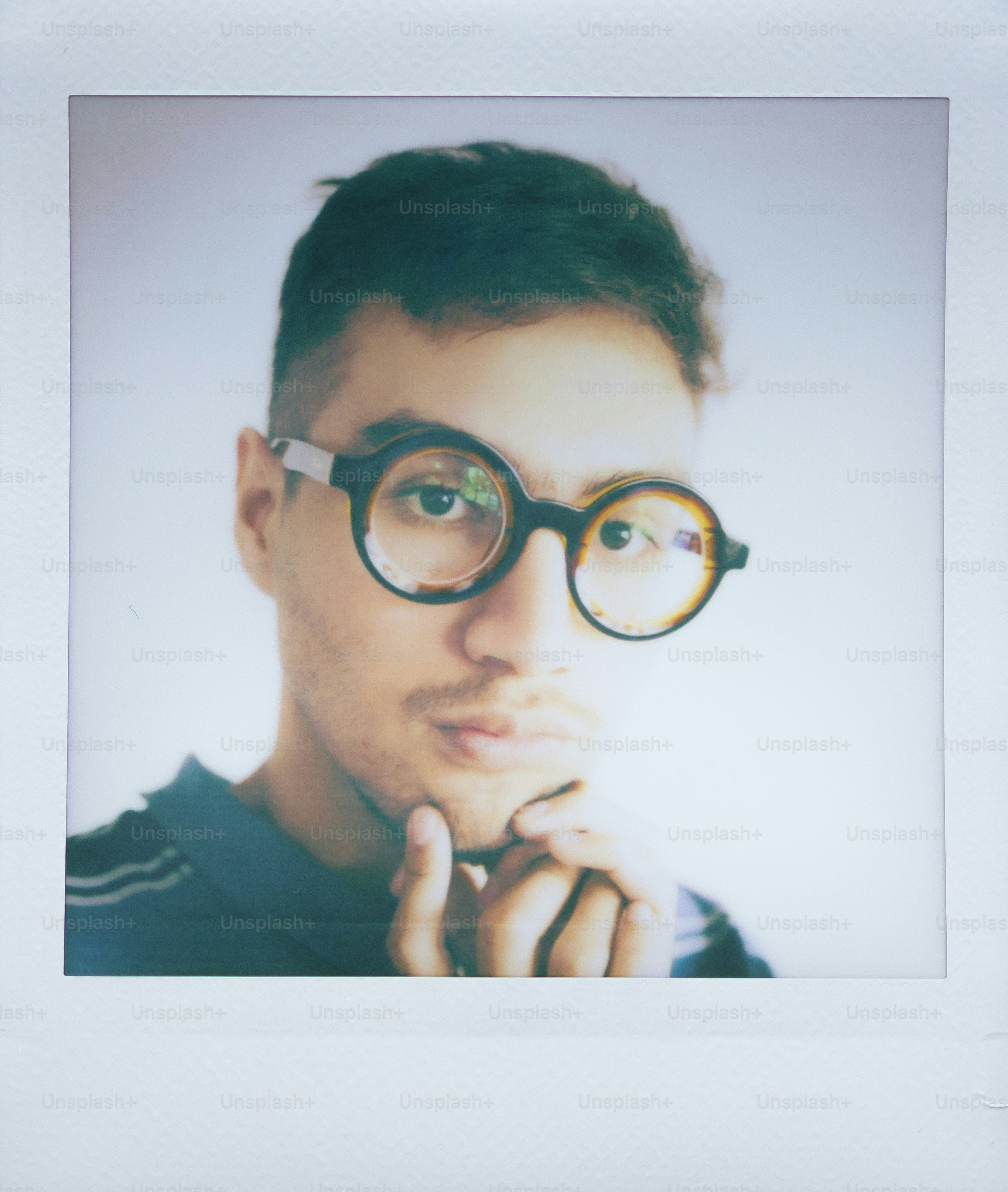 Man with round glasses looking thoughtfully