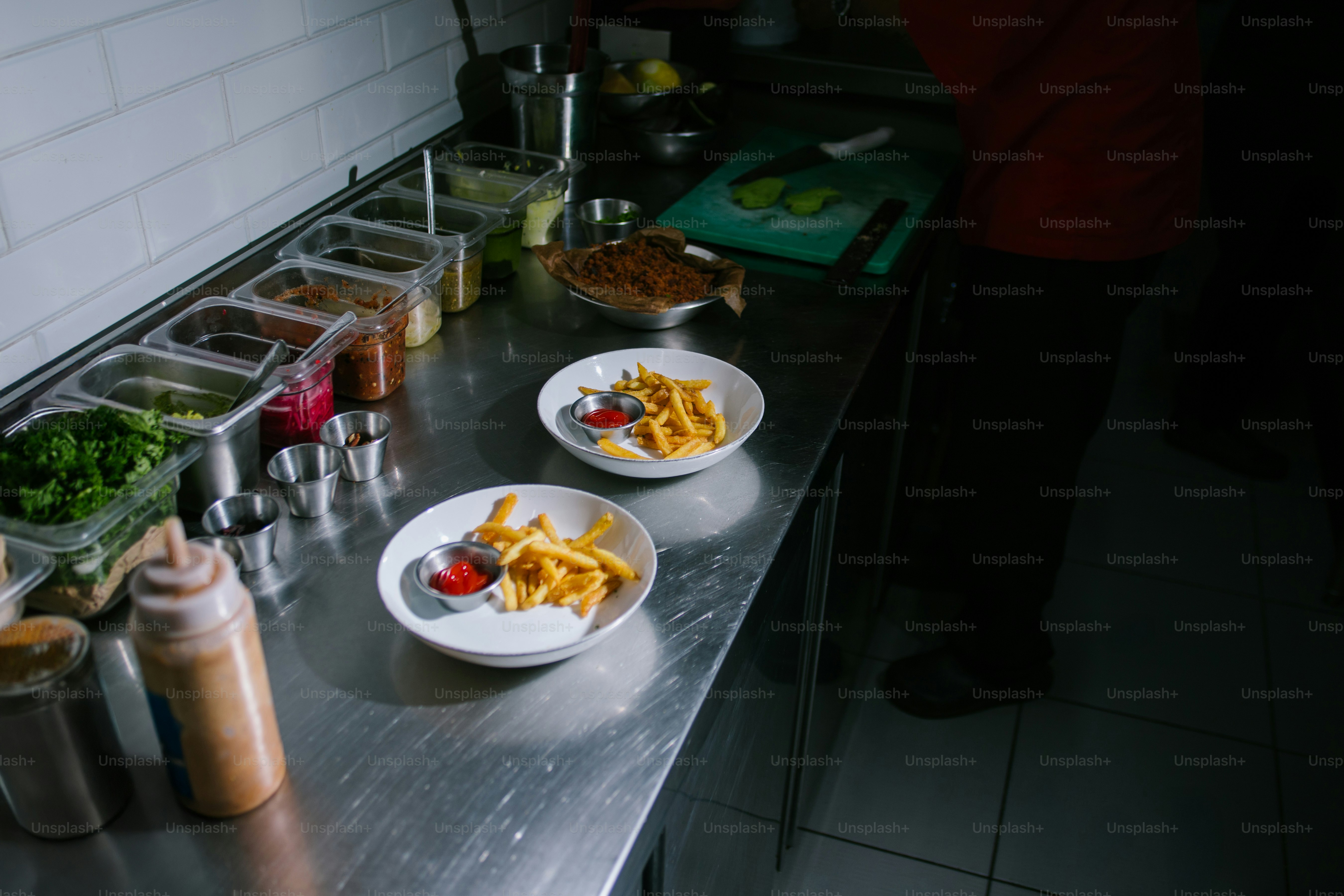 Two plates of french fries with ketchup served with ketchup.