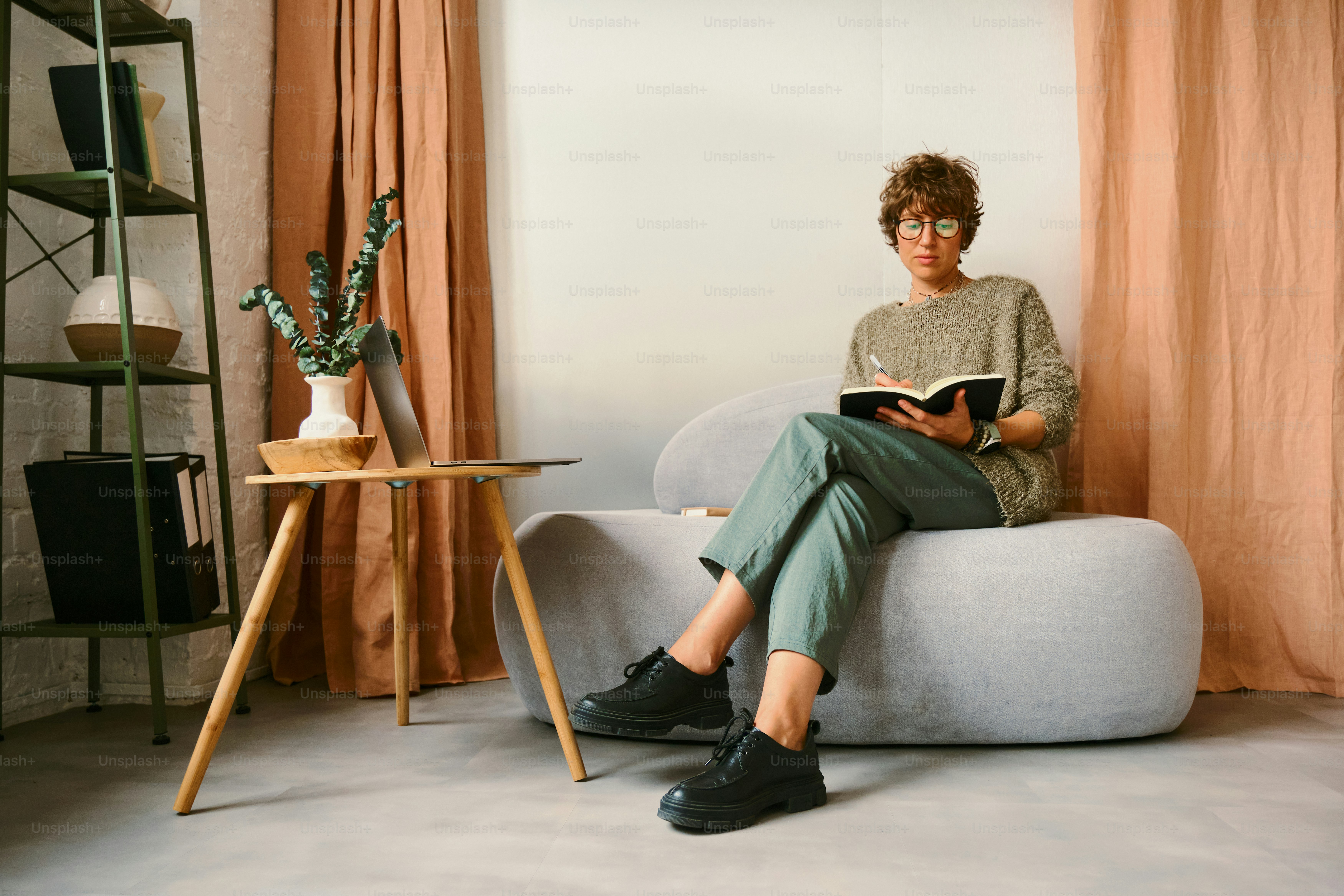 Mulher escrevendo em um caderno enquanto está sentado em uma cadeira.