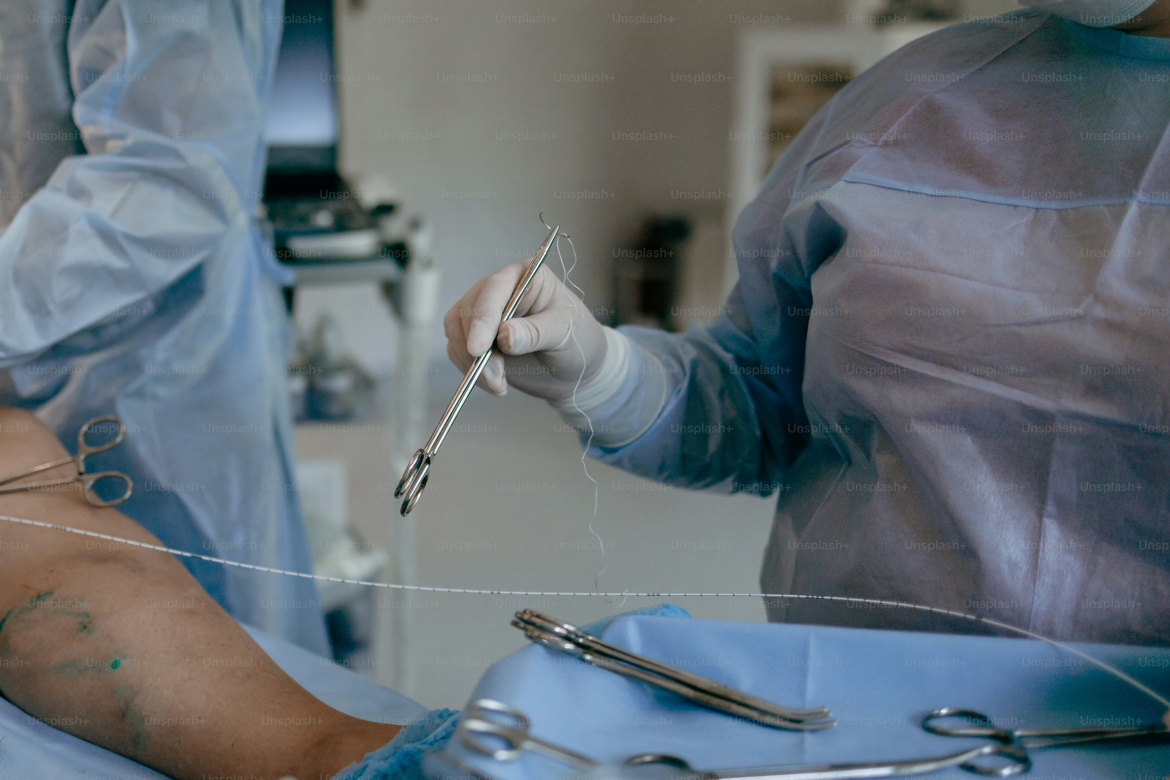 Surgeons performing a medical procedure with surgical instruments ...